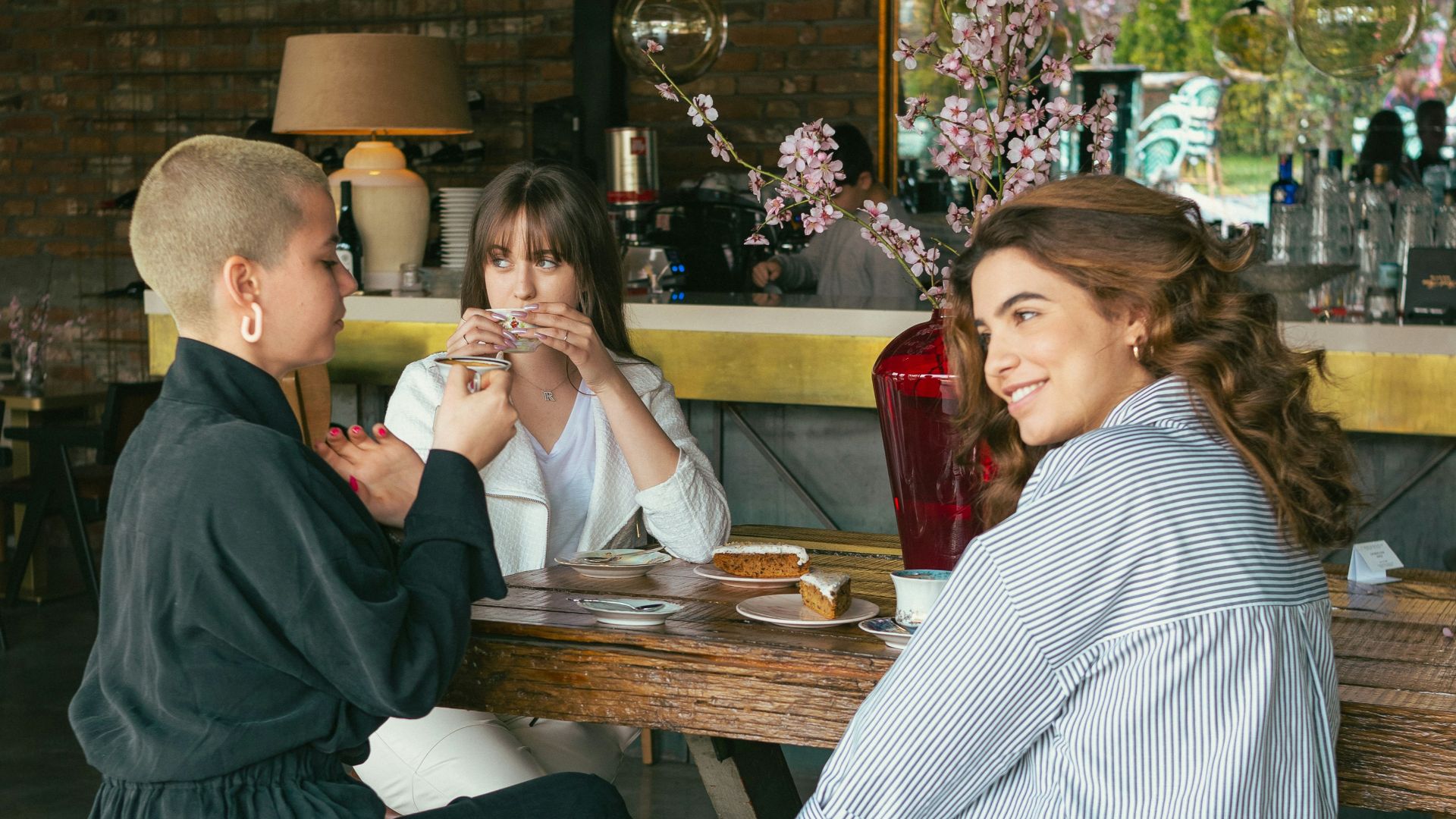 a woman sitting at a table with two other women
