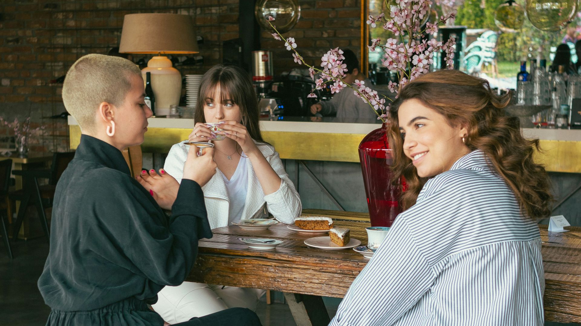 a woman sitting at a table with two other women