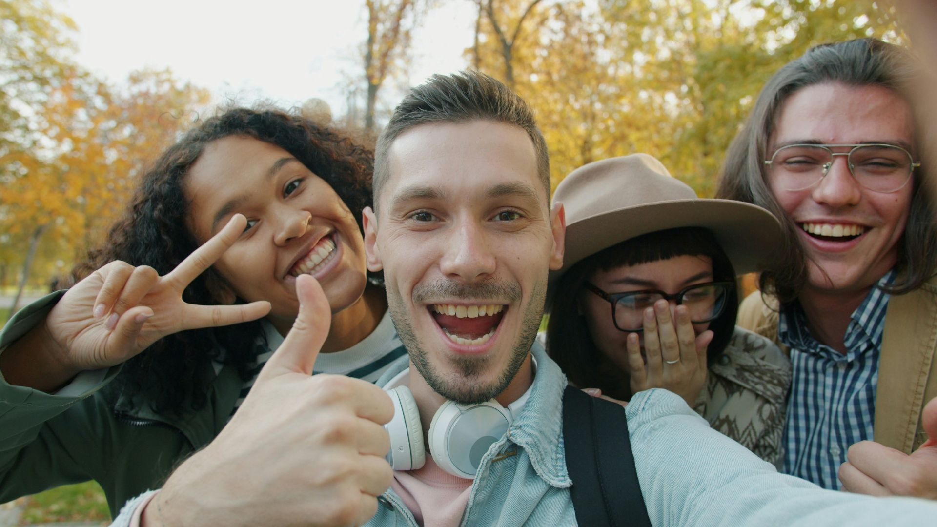 Four friends taking a happy selfie outdoors in autumn.