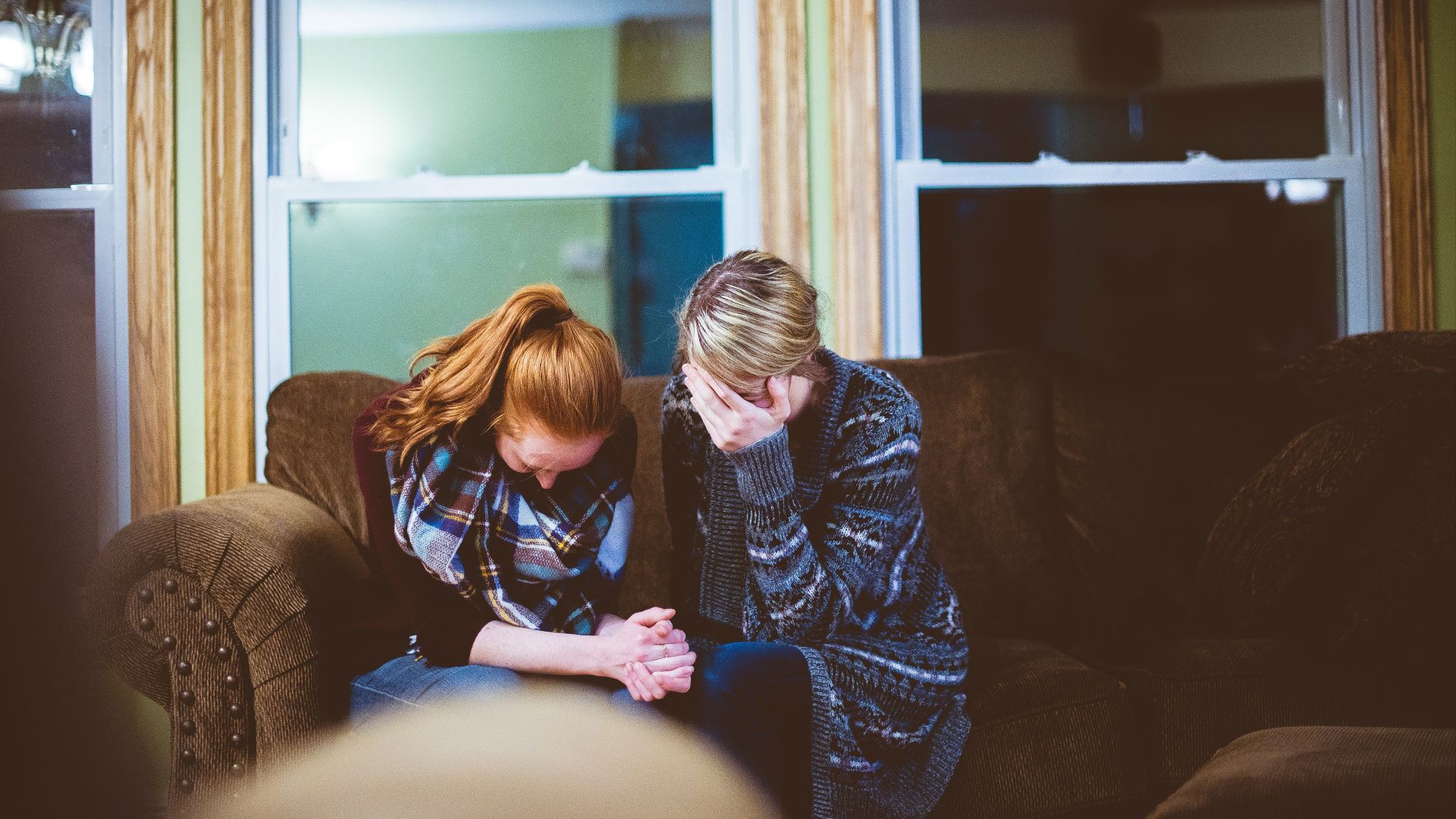man and woman sitting on sofa in a room