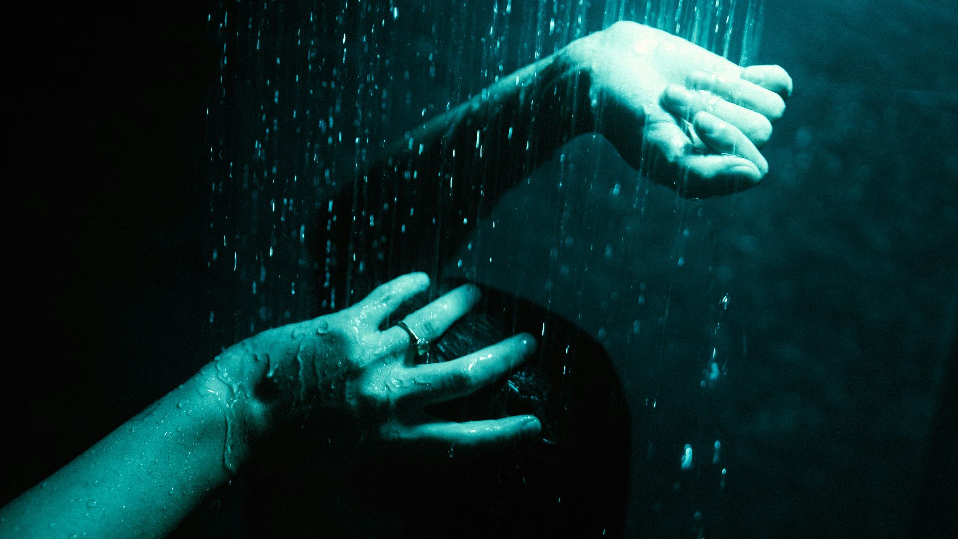 a woman's hand reaching for a shower head