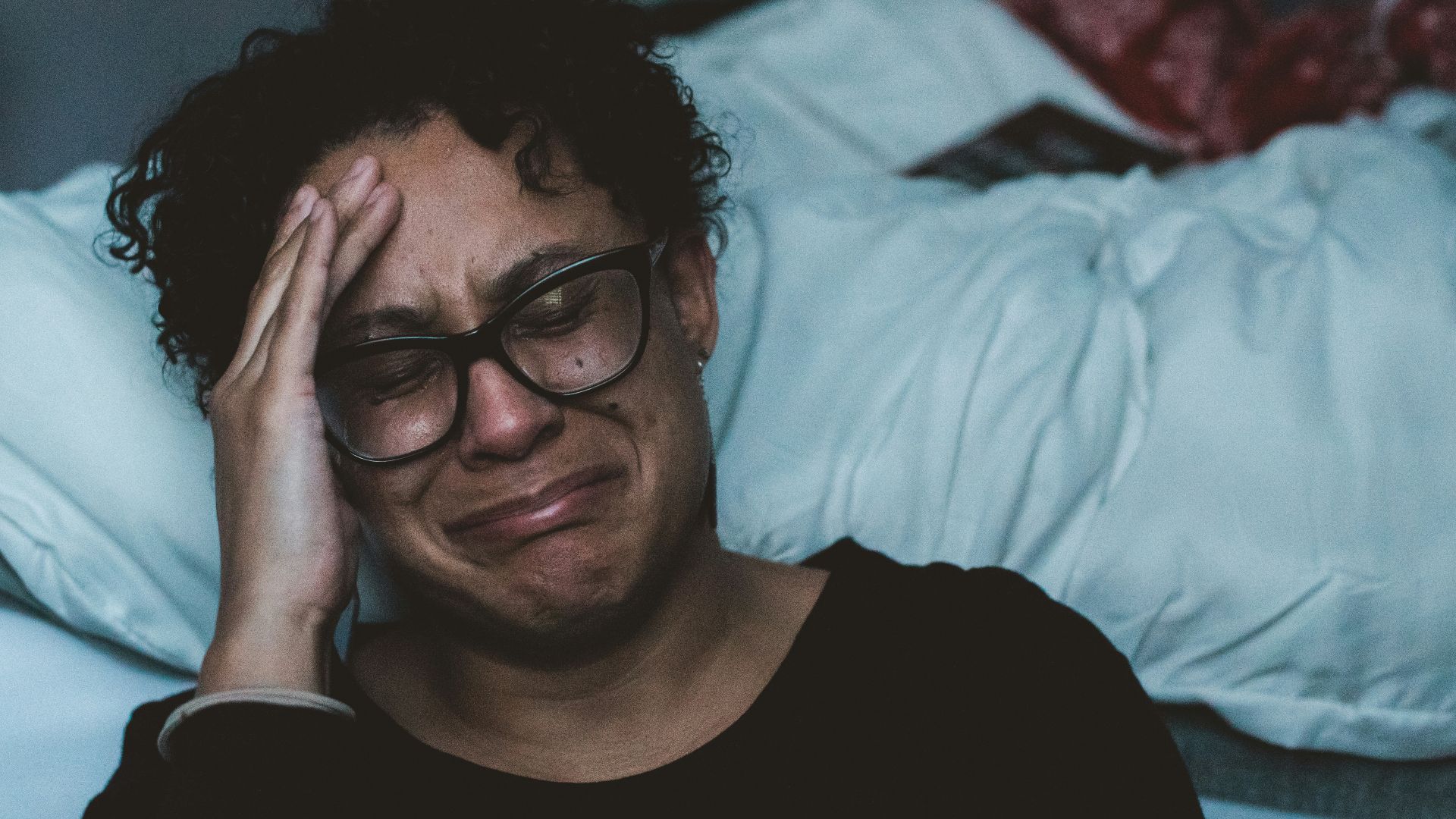 person crying beside bed
