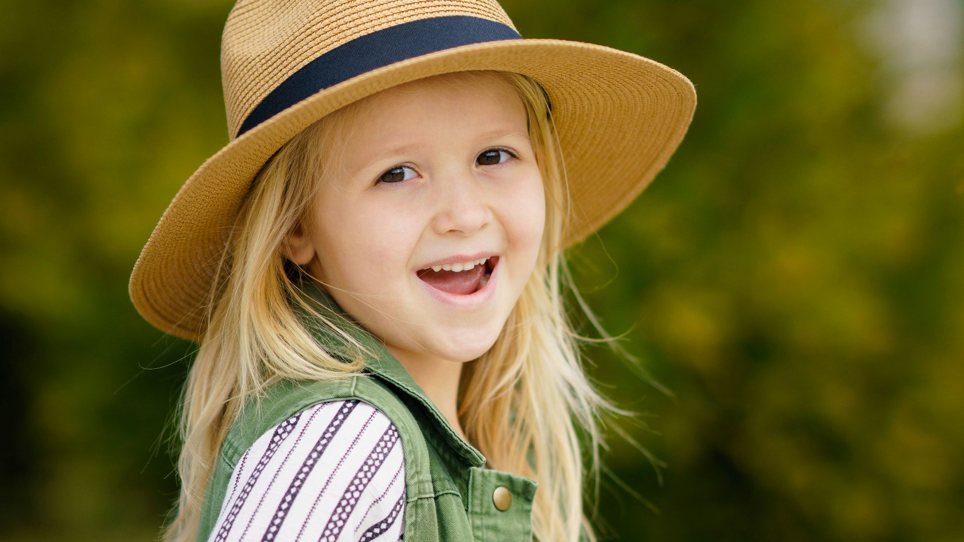 selective focus photography of girl smiling wearing sun hat