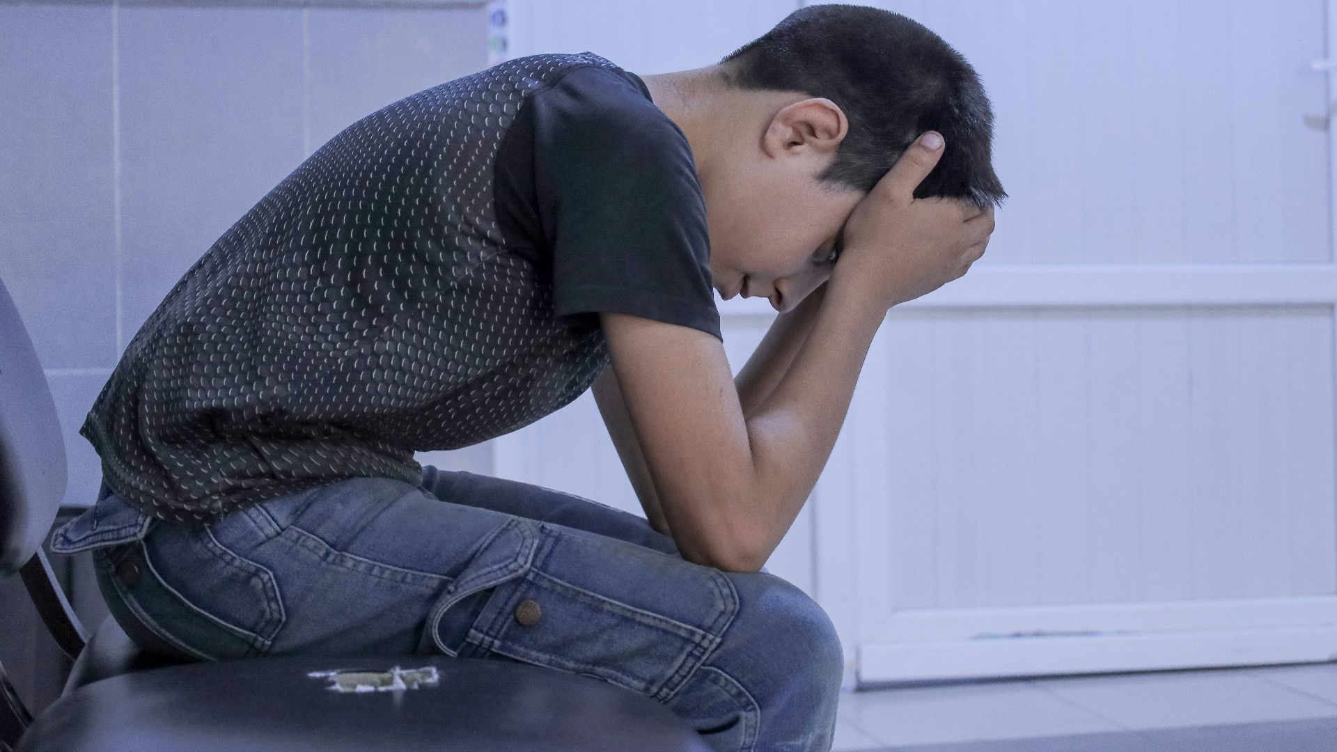 A man sitting on a chair with his head in his hands