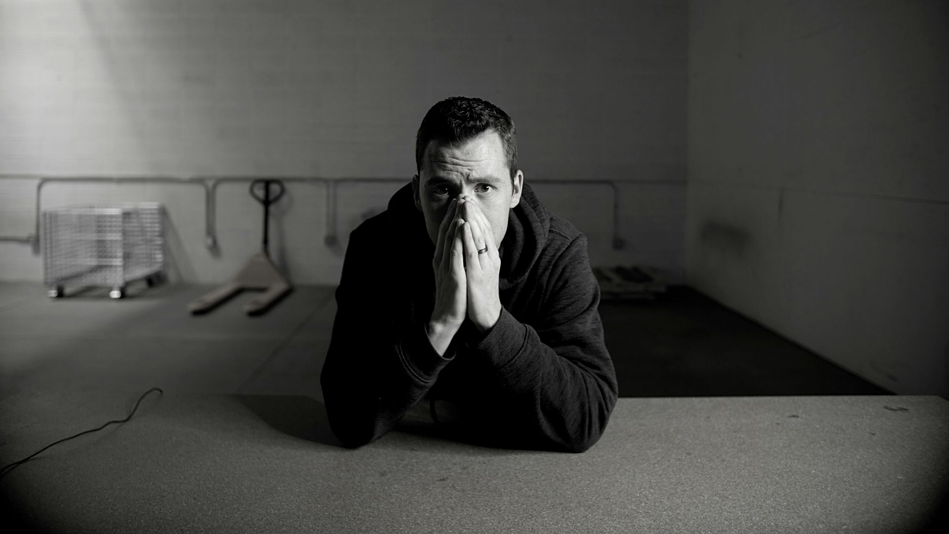 man in black jacket sitting on floor