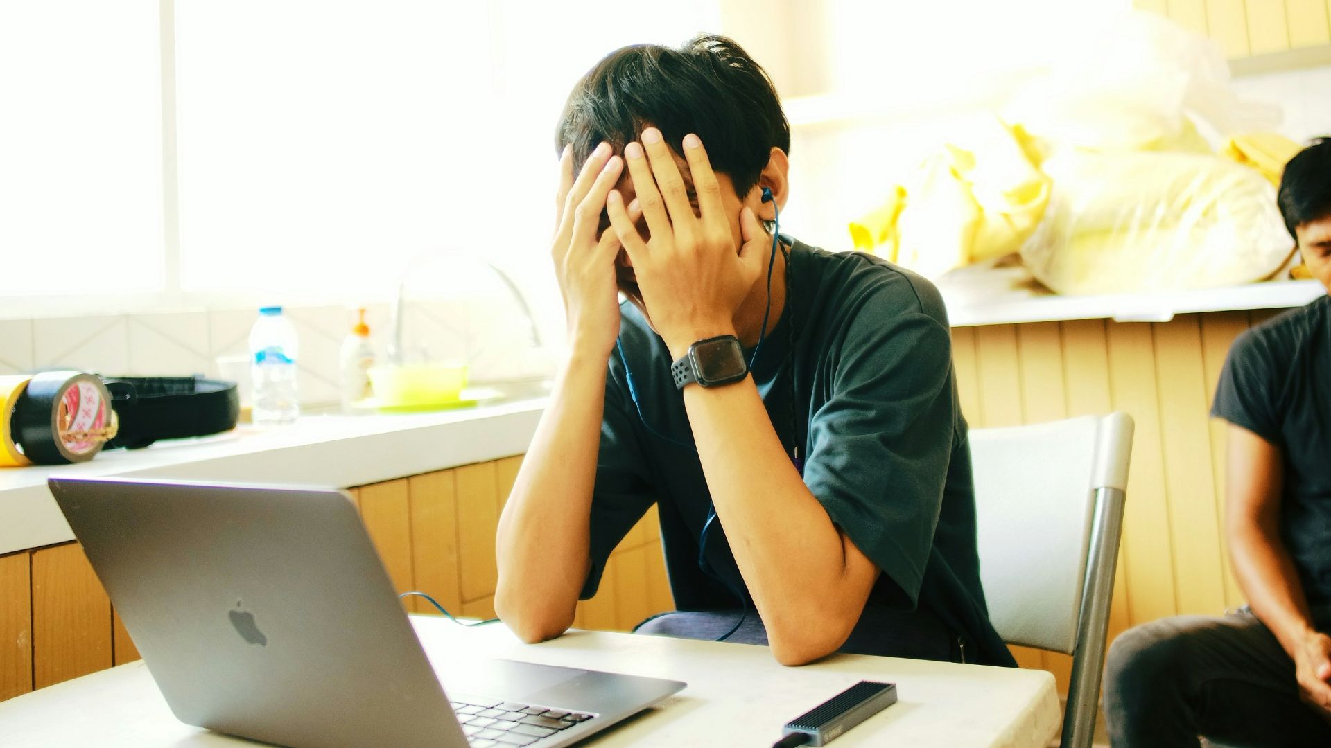 a person sitting at a desk with a laptop and a cell phone