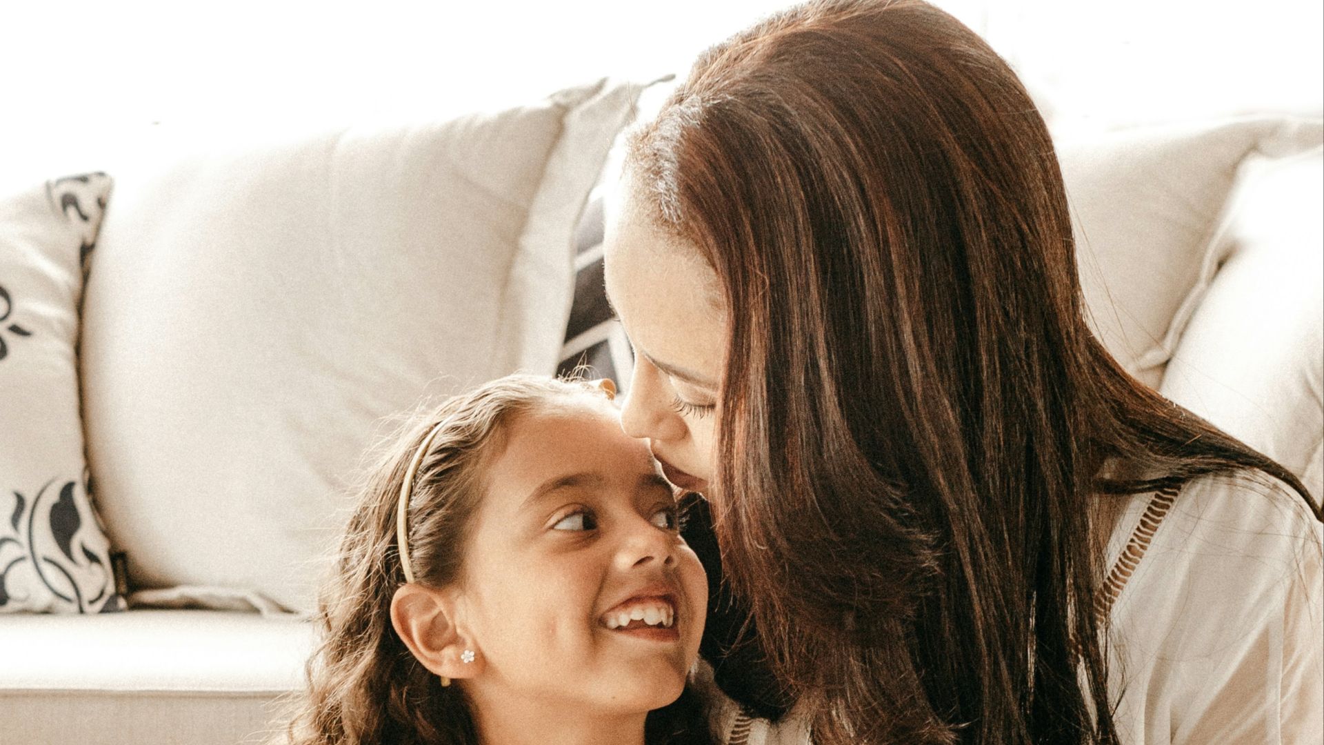 a woman sitting on the floor with a little girl