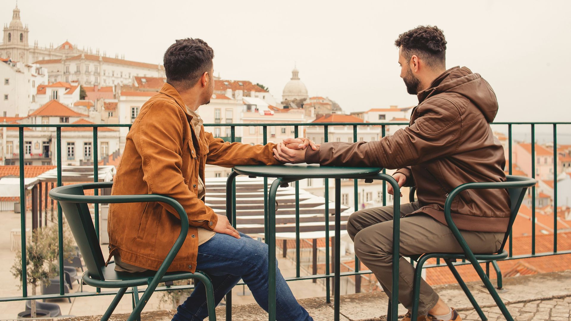 a couple of men sitting at a table next to each other