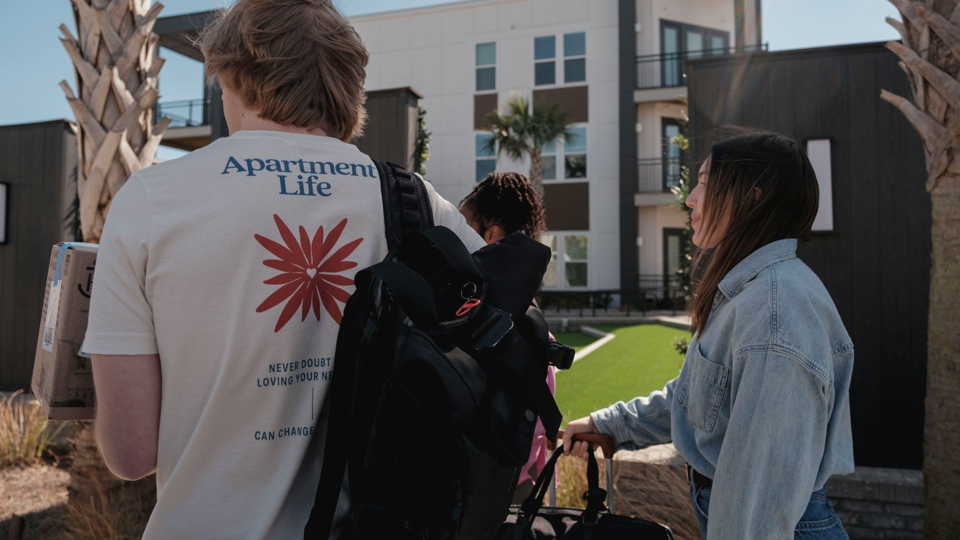 People walking towards modern apartment buildings.