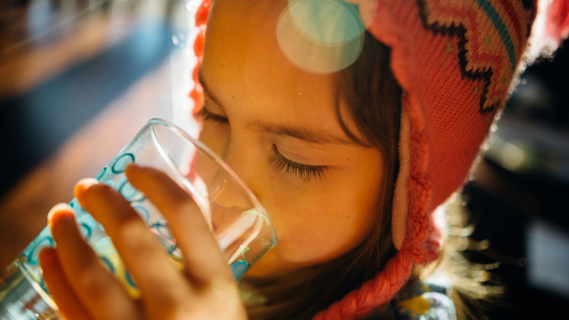 selective focus photography of girl drinking water