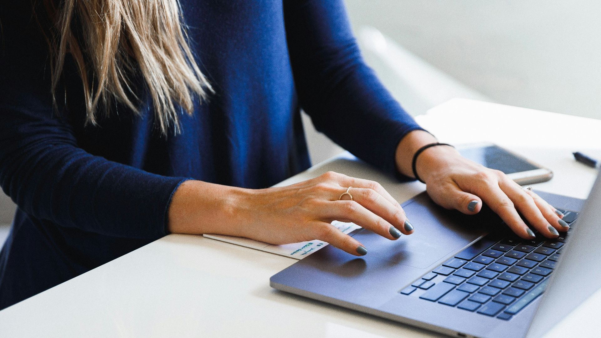 woman in blue long sleeve shirt using macbook pro