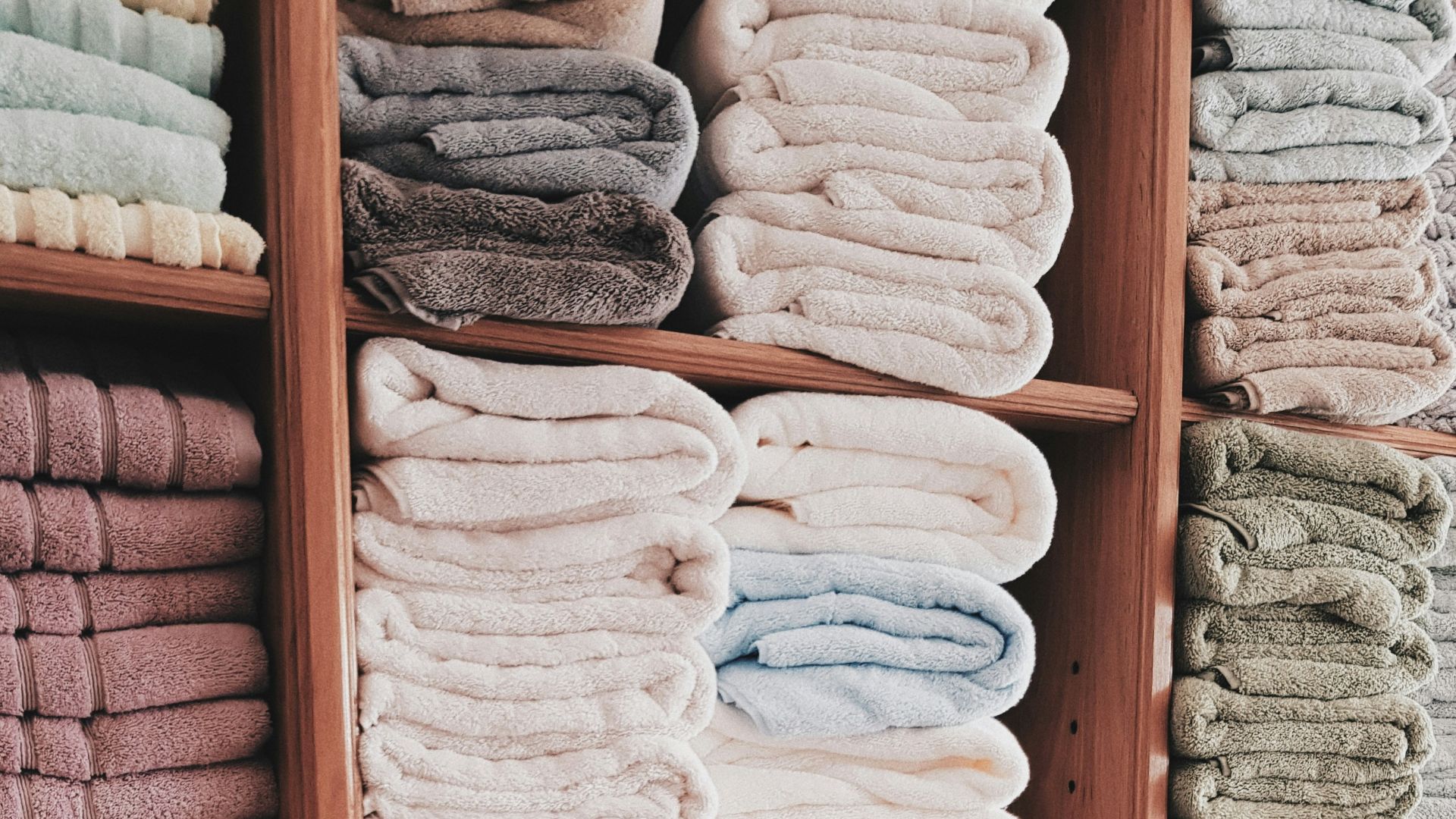 white and blue textile on brown wooden shelf