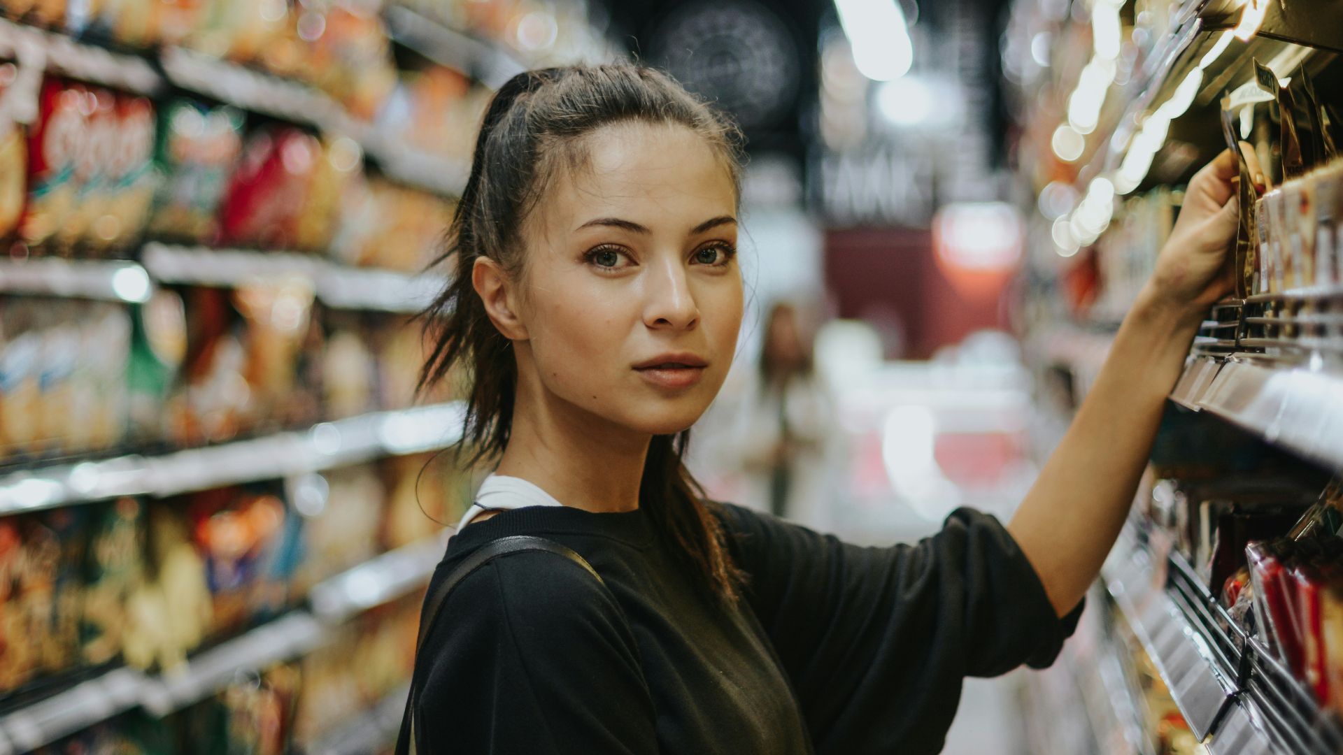 woman selecting packed food on gondola