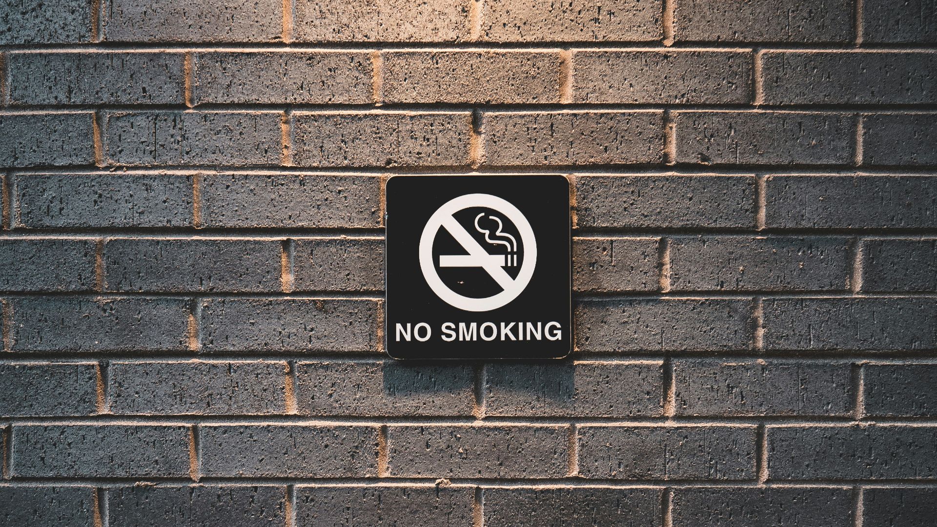 no smoking sign on brick wall