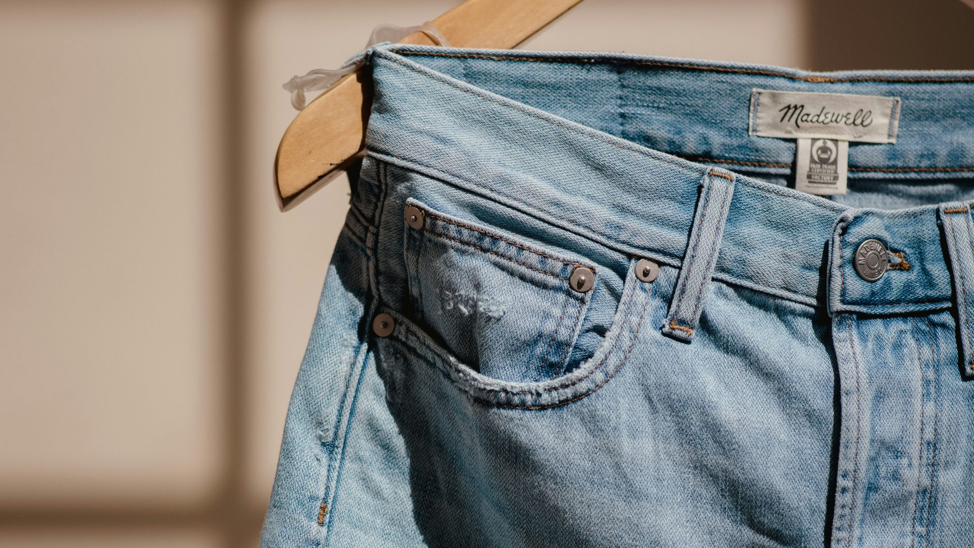 blue denim jeans on brown clothes hanger