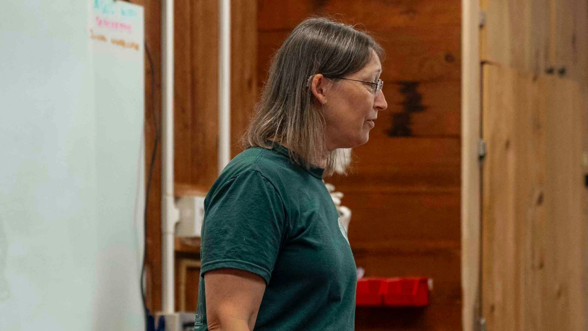 Woman standing near whiteboard in a wooden room