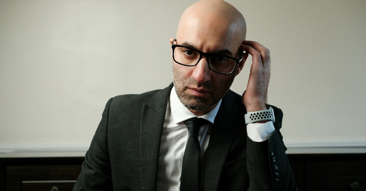 A man in a suit and tie sitting at a table