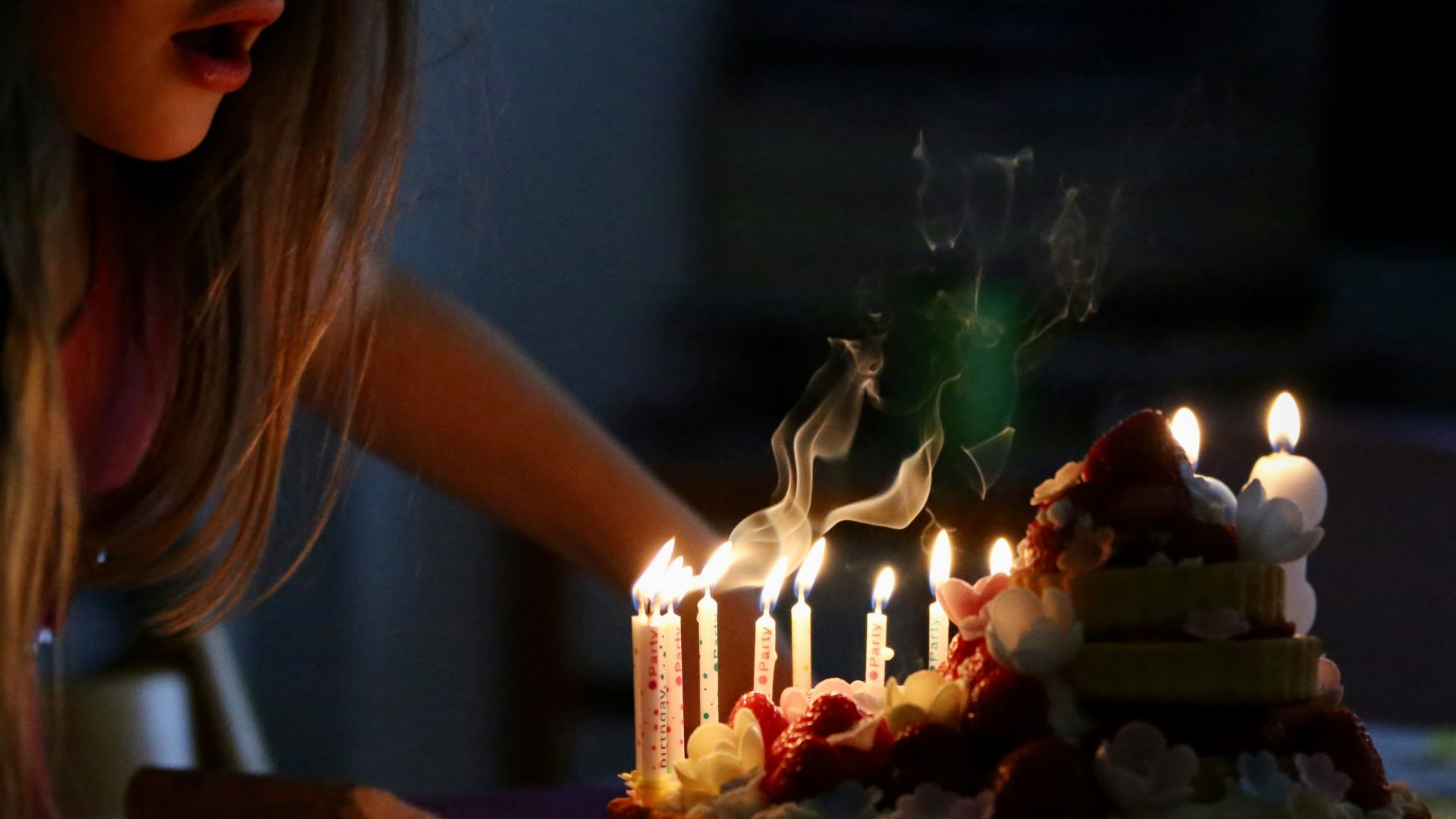 woman in white tank top holding lighted candles