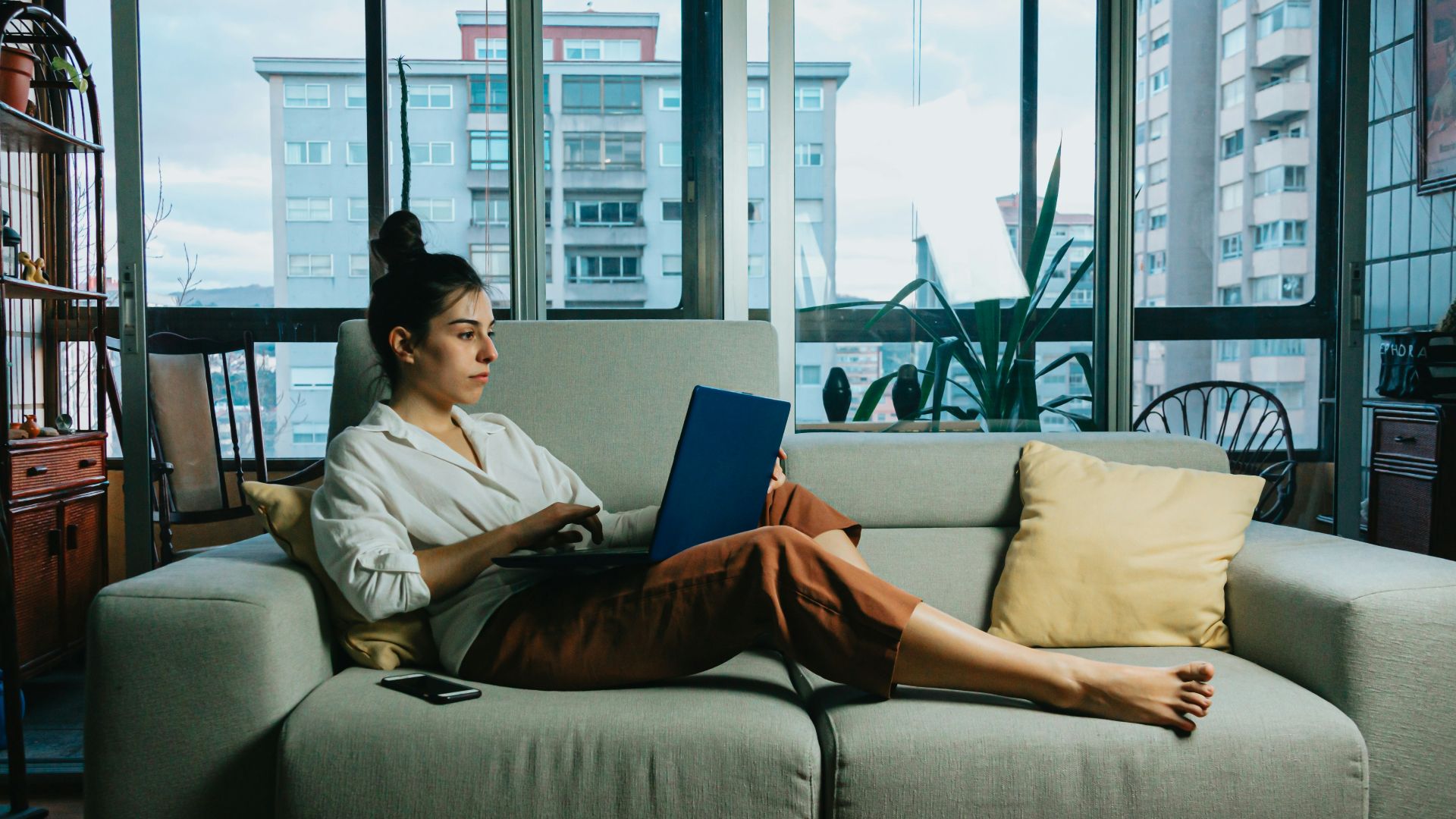 woman in white long sleeve shirt sitting on white couch