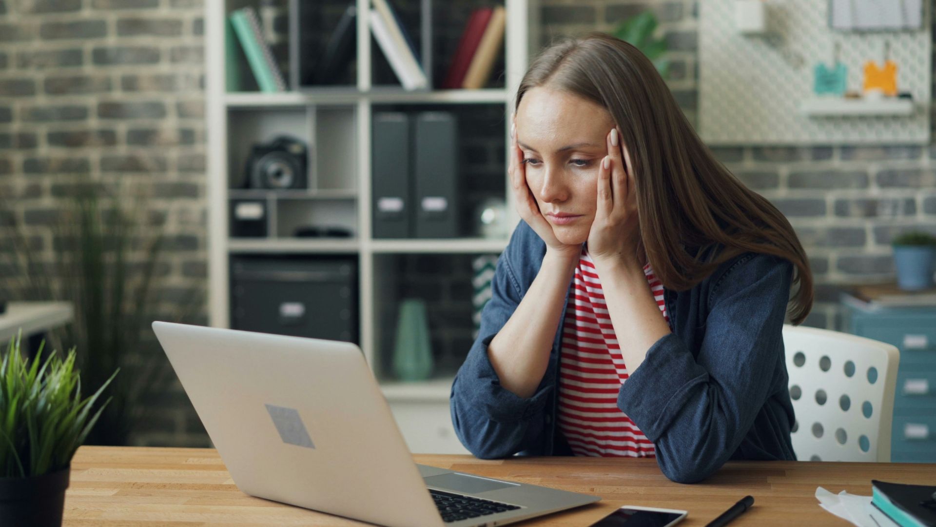 a woman sitting at a table with a laptop in front of her