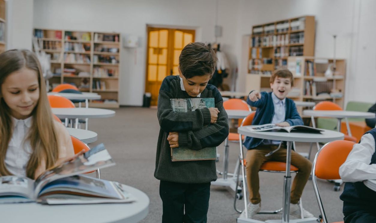 A Boy in Gray Sweater Holding a Book