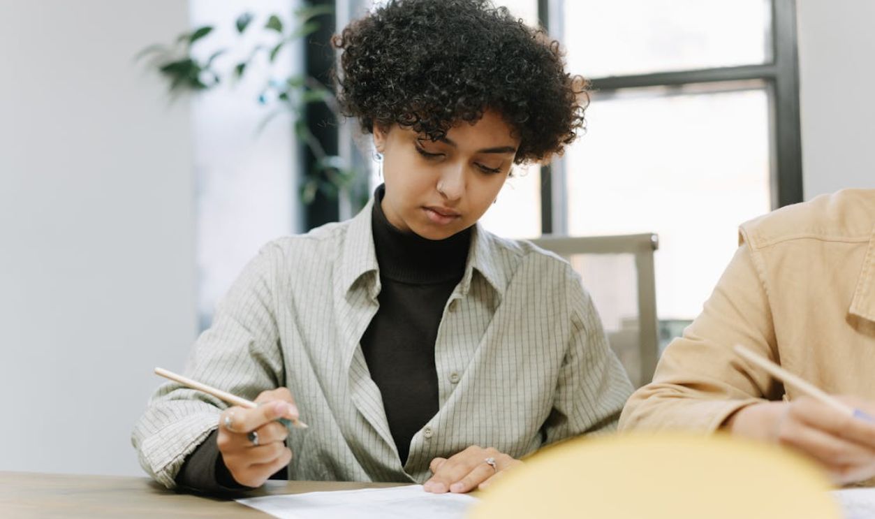 A Woman with Curly Hair while Writing