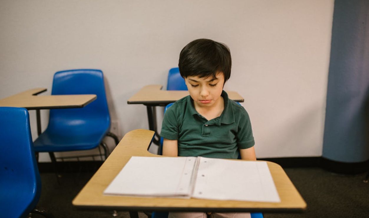 Boy Sitting on His Desk Looking Lonely