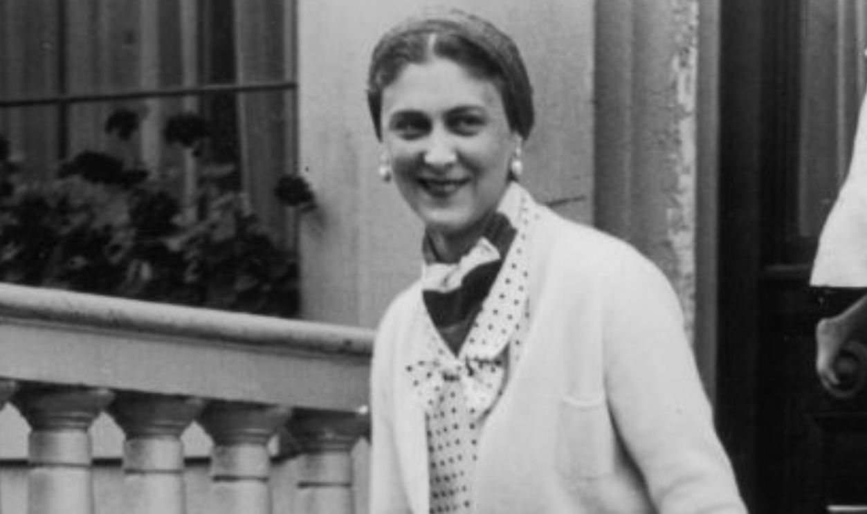 Princess Marina, Duchess of Kent (1906 - 1968) holds the hand of her son Prince Edward as they leave her house in Belgrave Square, London. A nanny carries Princess Alexandra, the Duchess's daughter. Princess Marina is wearing a spotted dress, cardigan, two coloured peep-toed shoes, gauntlet gloves and carries a small clutch bag. 