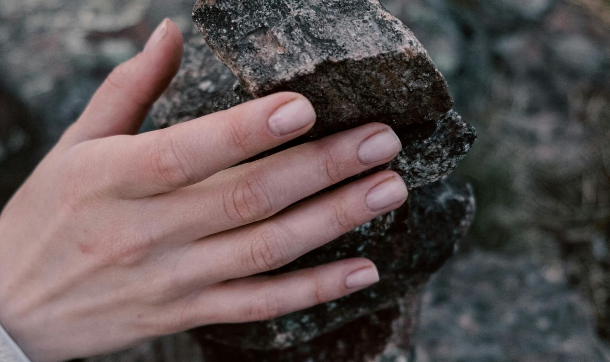 Close-Up Photo of a Person Holding a Pile of Rocks