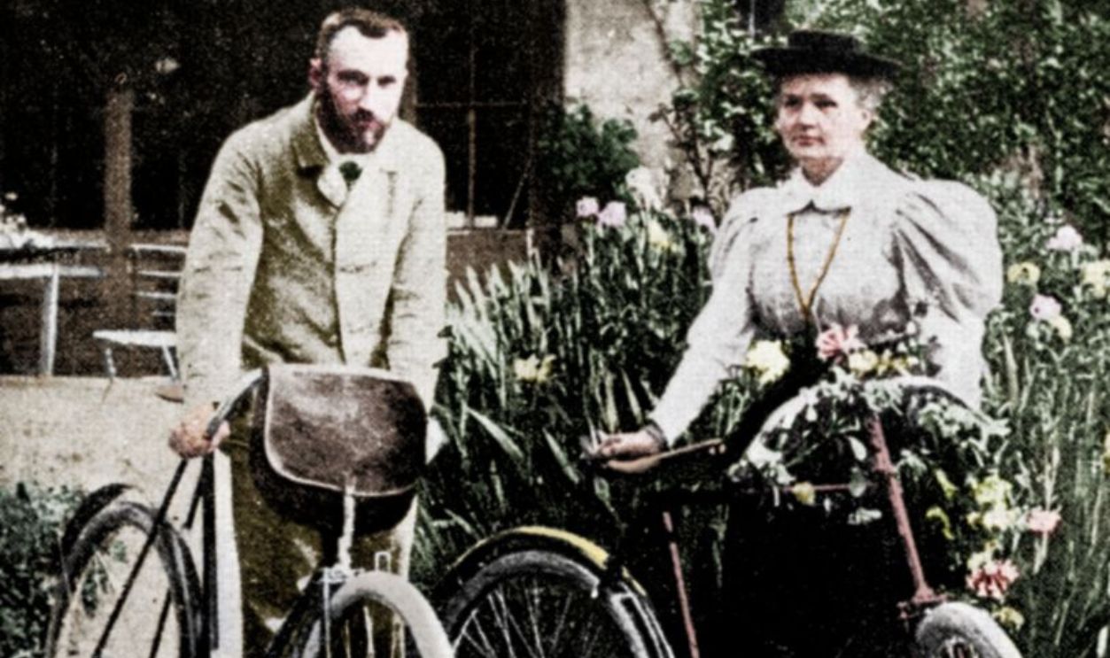 Pierre and Marie Curie, French physicists, preparing to go cycling. Polish-born Marie Curie and her husband Pierre continued the work on radioactivity started by Henri Becquerel. In 1898, they discovered two new elements, polonium and radium. Marie did most of the work of producing these elements, and to this day her notebooks are still too radioactive to use. She went on to become the first woman to be awarded a doctorate in France, and continued her work after Pierre's death in 1906. In 1903 they shared the Nobel Prize for Physics with Becquerel. Marie won a second Nobel Prize, for chemistry, in 1911. (Colorised black and white print). Artist Unknown. 