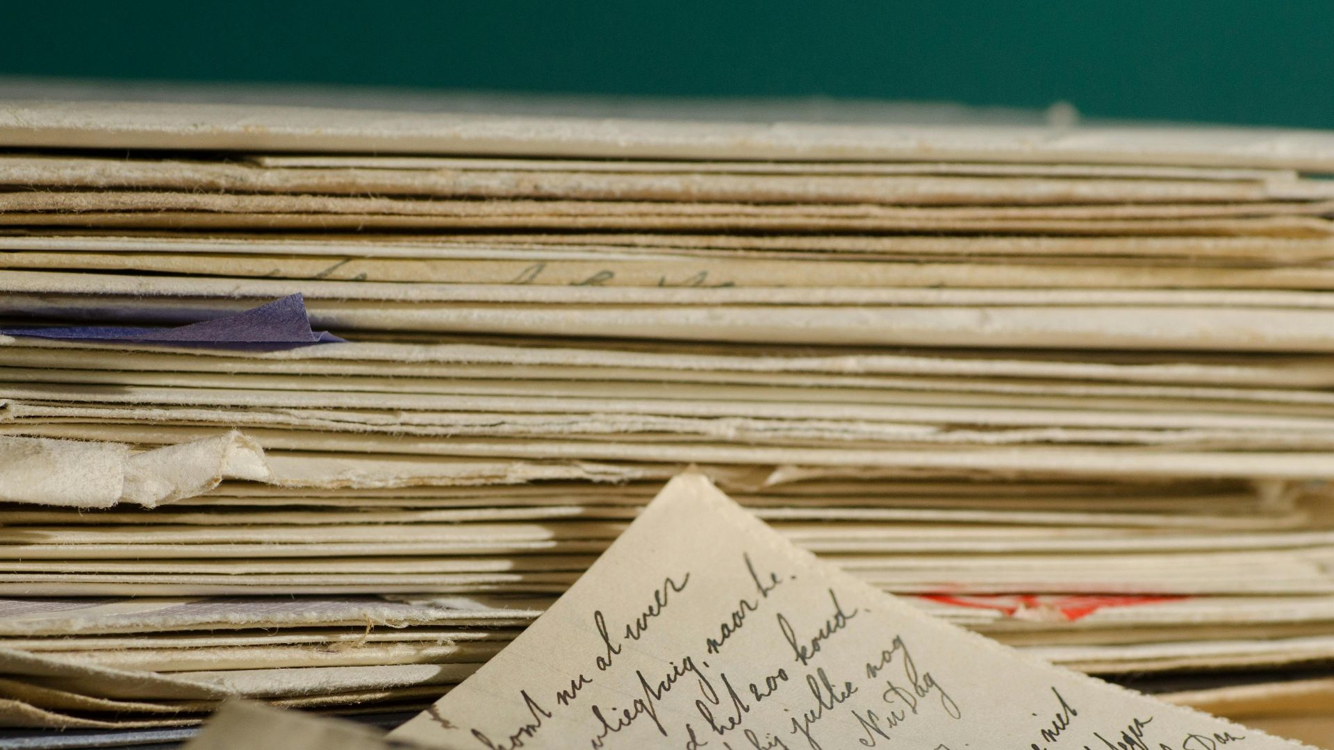Close-up image of handwritten letters and papers stacked together, conveying a vintage feel.