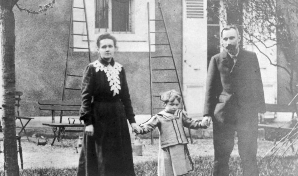 Polish-born physicist Marie Curie (1867 - 1934) and her husband, French chemist Pierre Curie (1859 - 1906), holding hands with their daughter, Irene, in the garden of their home at 108, Boulevard Kellerman, Paris, France, circa 1902.