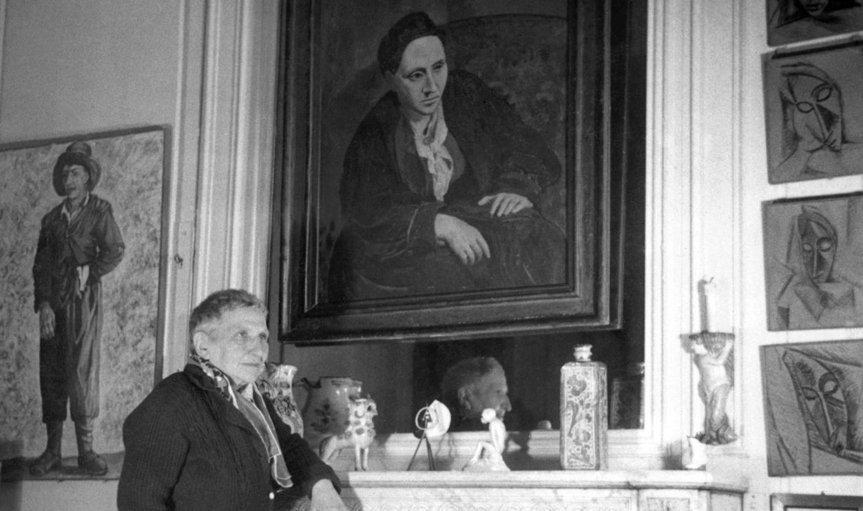 Gettyimages - 51502109, US writer Gertrude Stein (1874-1946) poses in fron PARIS, FRANCE: US writer Gertrude Stein (1874-1946) poses in front of the portrait of her (painted by Picasso in 1906), at her Parisian apartment in an undated photograph.