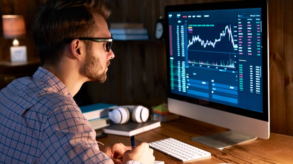 Serious business man trader analyst looking at computer monitor