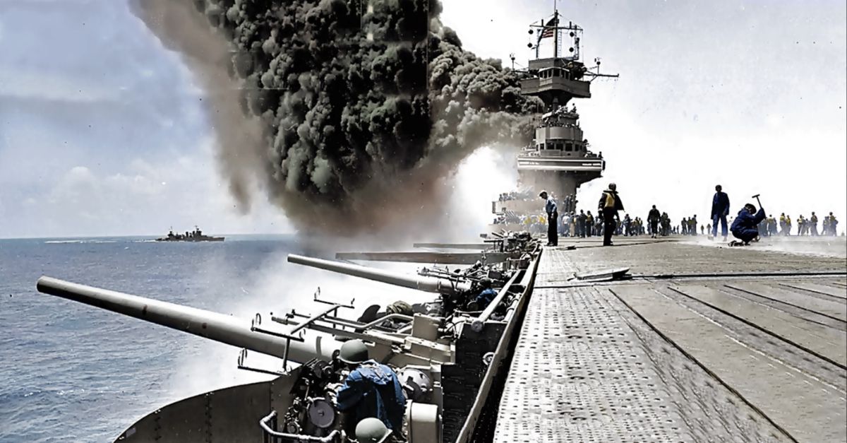 Scene on board USS Yorktown (CV-5), during the Battle of Midway, 4 June 1942, shortly after she was hit by three Japanese bombs on the same day, what would cause the sinking of the aircraft carrier on 7 June 1942, in which 141 men were killed. The Battle of Midway, however, was a decisive naval and air battle for the US Navy and widely considered a turning point in the Pacific War. Dense smoke is from fires in her uptakes, caused by a bomb that punctured them and knocked out her boilers. The engineer with the hammer at the right side is most likely covering a bomb entry hole in the forward elevator. Note arresting gear cables and forward palisade elements on the flight deck; CXAM radar antenna, large national ensign and YE homing beacon antenna atop the foremast; 5
