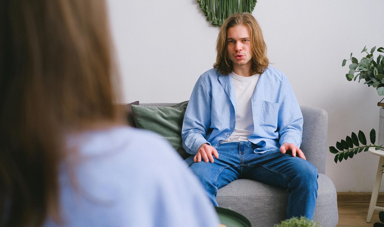 Young adult in a therapy session, discussing and expressing concerns in a modern office setting