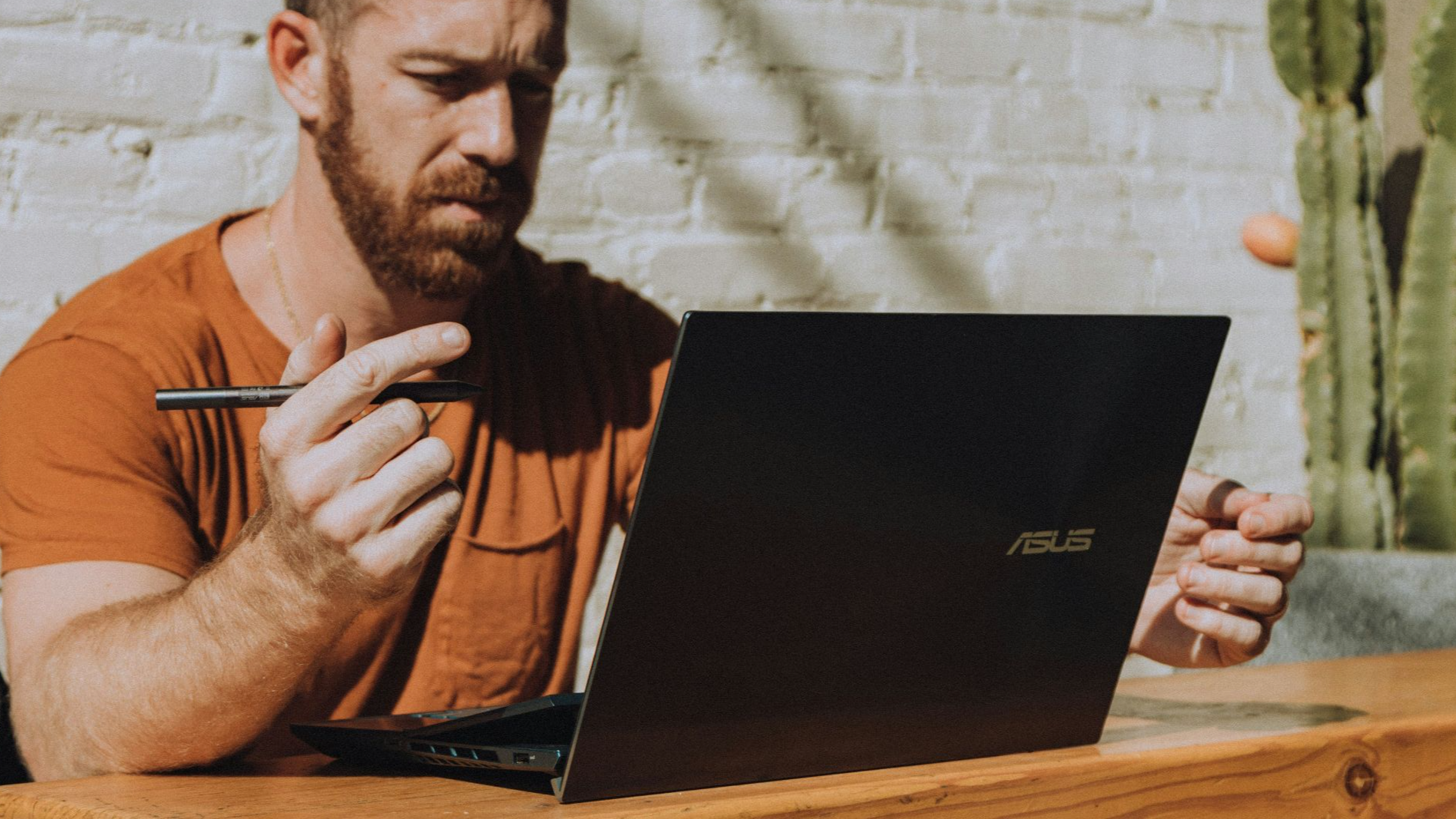 a man sitting at a table using a laptop computer