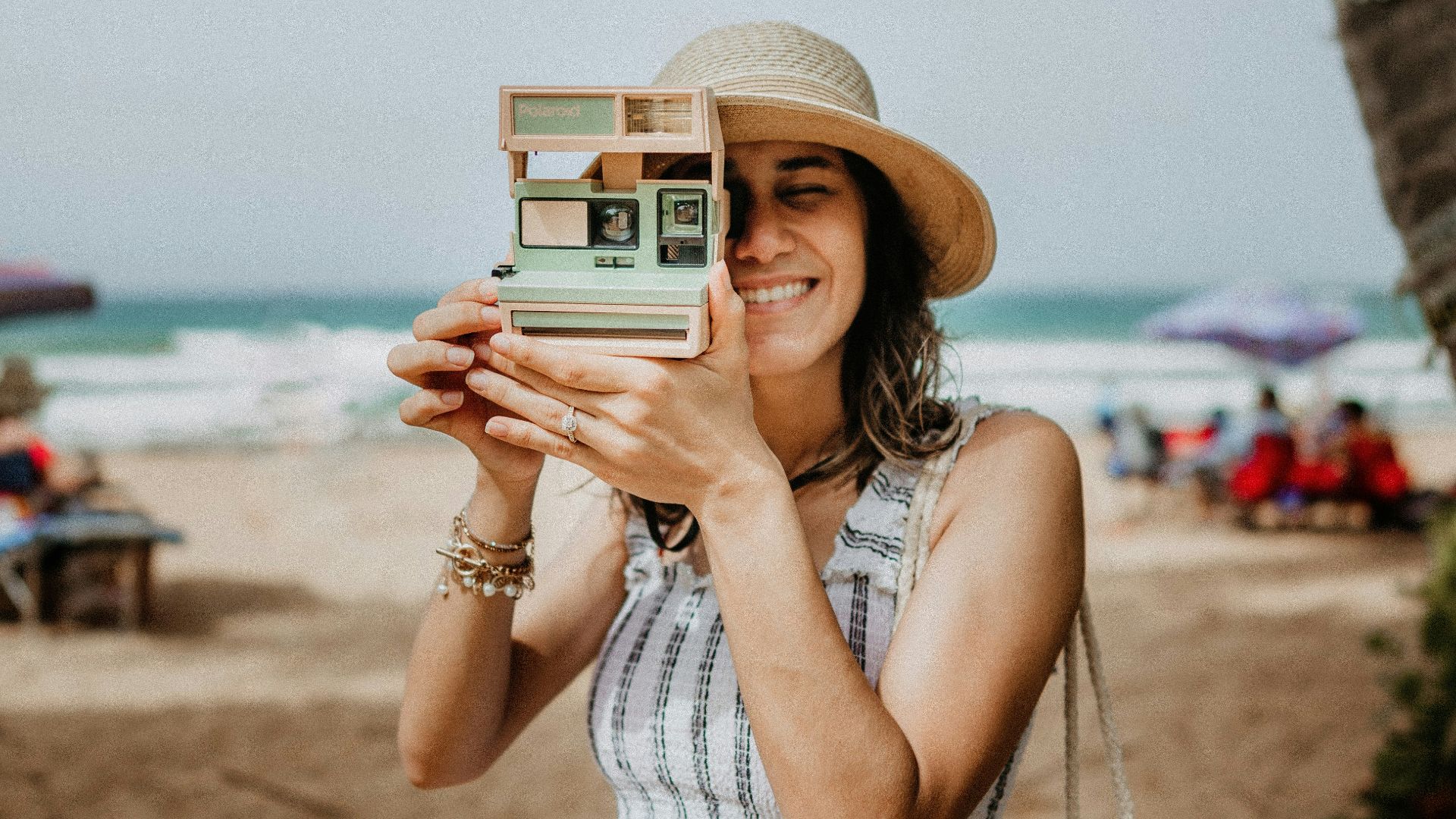 woman in white and blue stripe dress holding white and black camera