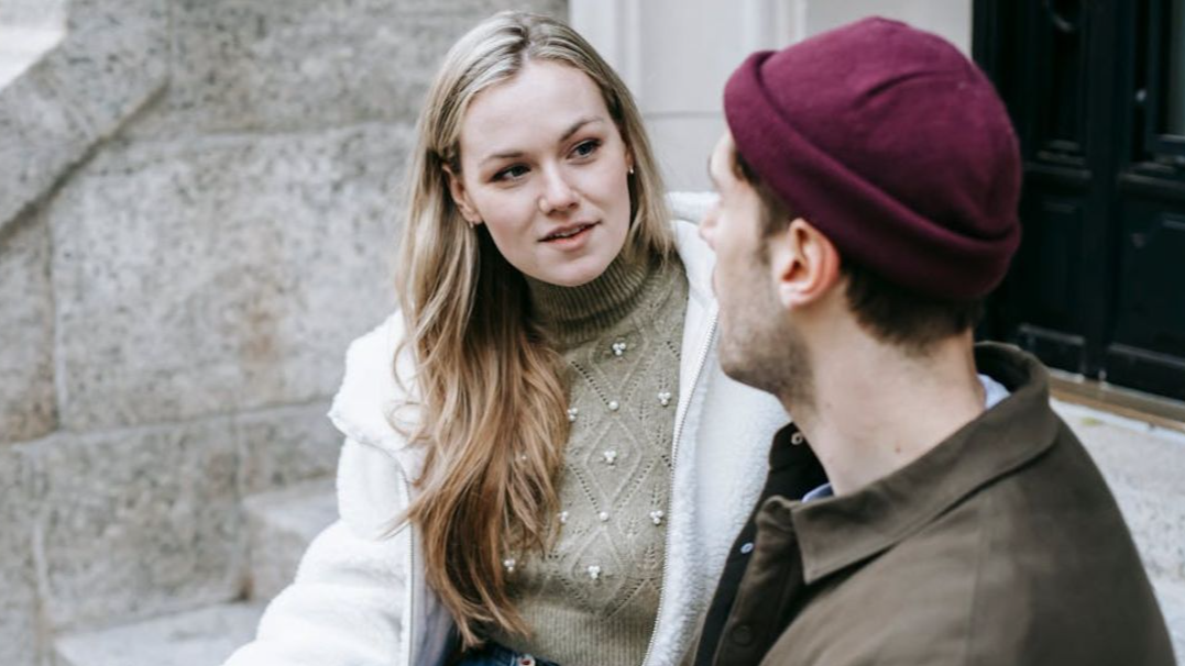Young couple talking and drinking beverages on stairs