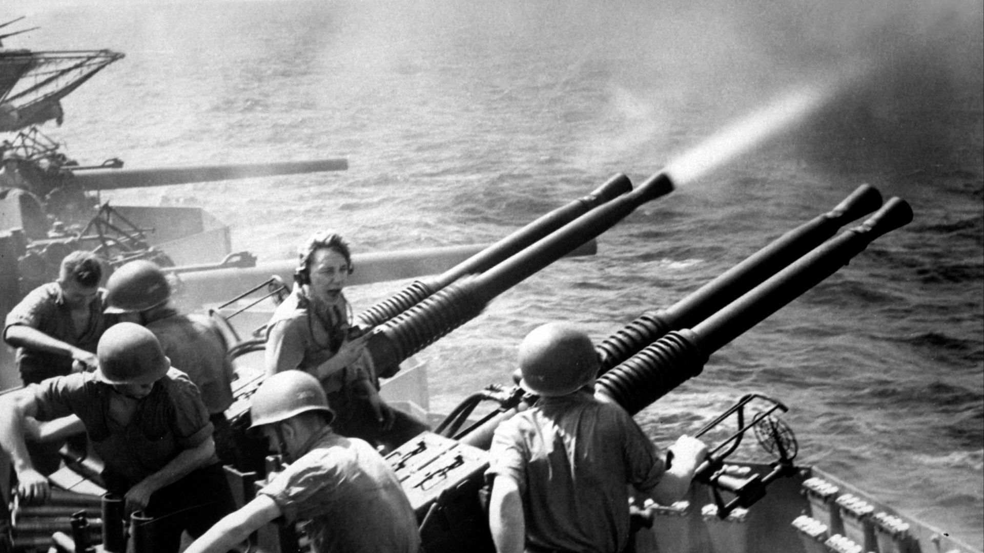 40mm guns firing aboard the U.S. aircraft carrier USS Hornet (CV-12) on 16 February 1945, as the planes of Task Force 58 were raiding Tokyo. Note expended shells and ready-service ammunition at right.