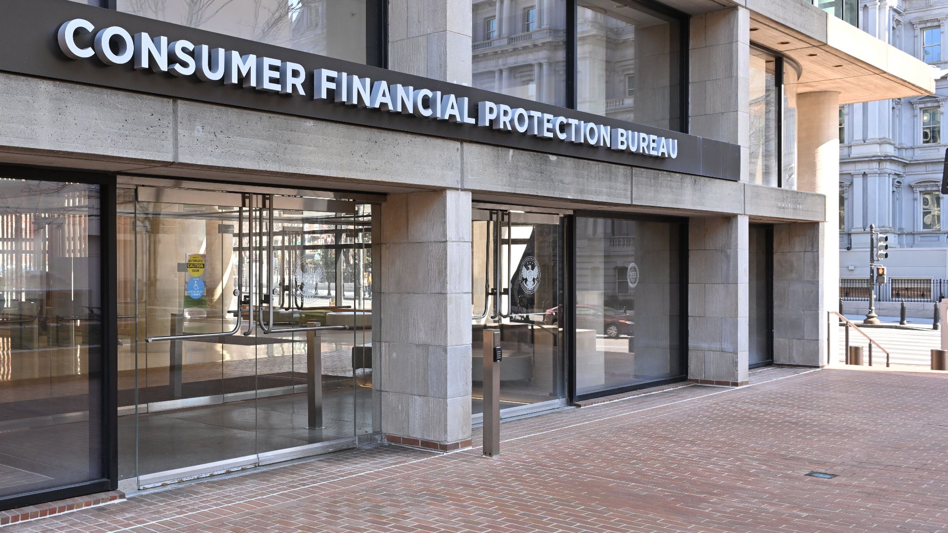 The entrance to the Consumer Financial Protection Bureau headquarters with the bureau's name above it. 1700 G Street NW, Washington, DC 20552.