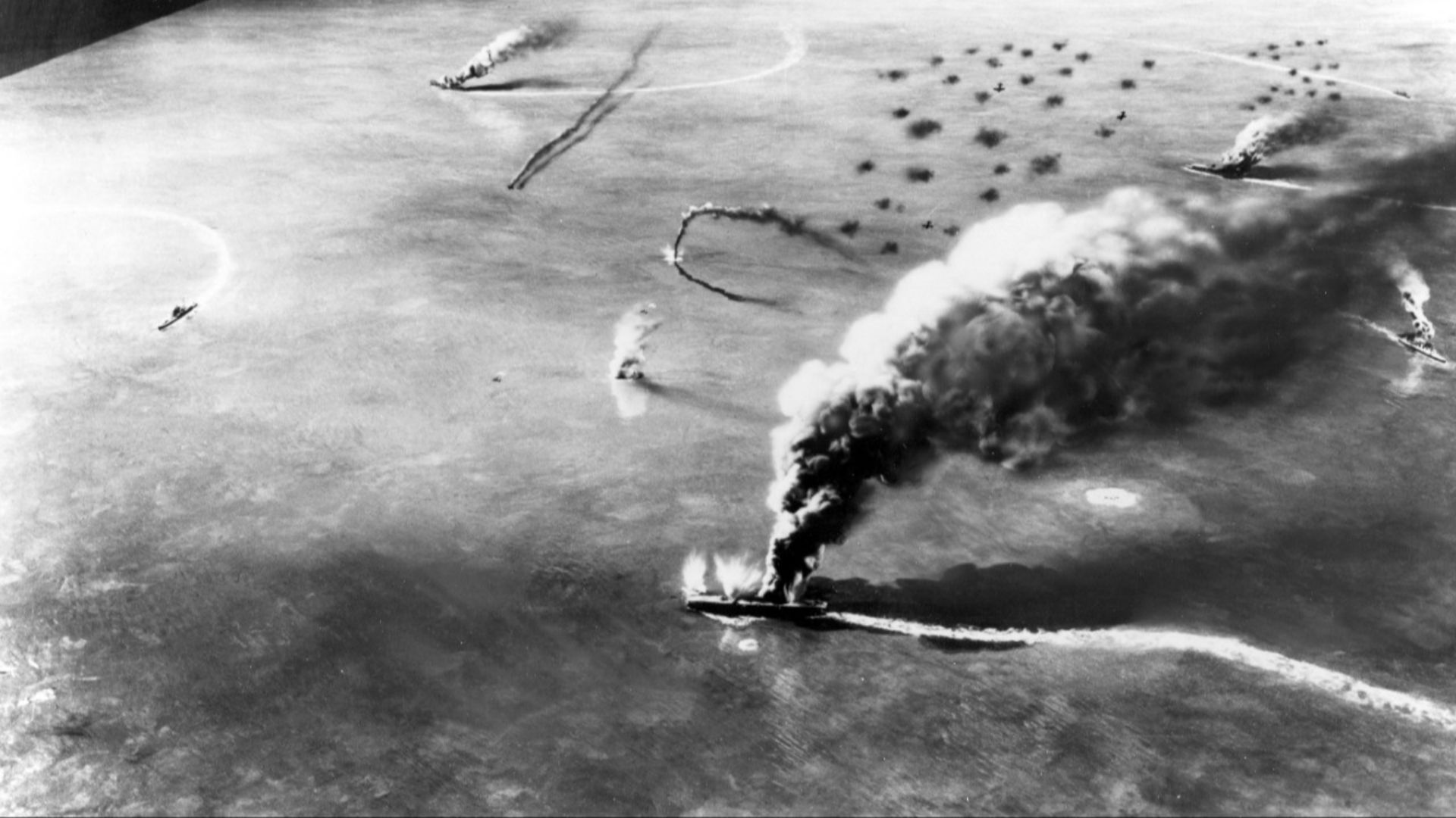 Battle of Midway, June 1942. 
Diorama by Norman Bel Geddes, depicting the attack by USS Yorktown (CV-5) and USS Enterprise (CV-6) dive bombers on the Japanese aircraft carriers Soryu, Akagi and Kaga in the morning of 4 June 1942. The diorama was created during World War II on the basis of information then available. It is therefore somewhat inaccurate in scope and detail.
This angle of view is essentially the reciprocal of that shown in Photo # 80-G-701869. It depicts Soryu (attacked by Yorktown aircraft) in the center foreground, with Kaga and Akagi (both attacked by Enterprise aircraft) as the two most distant burning ships. The burning ship at far right is a light cruiser, which had been erroneously reported to have been hit.