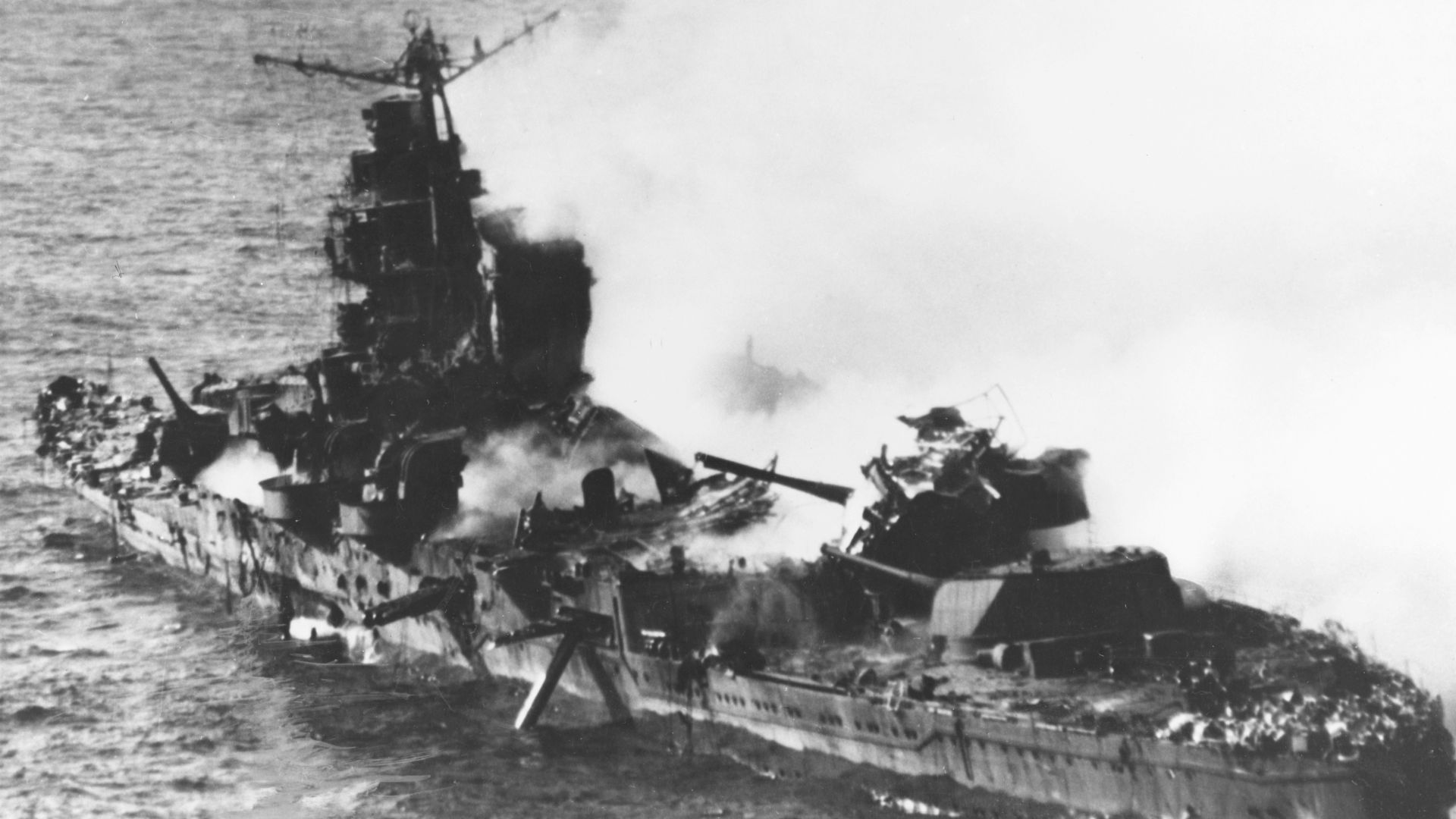 The Japanese heavy cruiser Mikuma, photographed from a USS Enterprise (CV-6) Douglas SBD-3 Dauntless during the afternoon of 6 June 1942, after she had been bombed by planes from Enterprise and USS Hornet (CV-8). Note her shattered midships structure, torpedo dangling from the after port side tubes and wreckage atop her number four 203 mm gun turret.The photo flight was led by Lt(jg) E.J. Kroeger, A-V(N), USNR, of Bombing Squadron 6 (VB-6) with photographer Mr. A.D. Brick of Fox Movietone News in a SBD-3 of VB-3 (