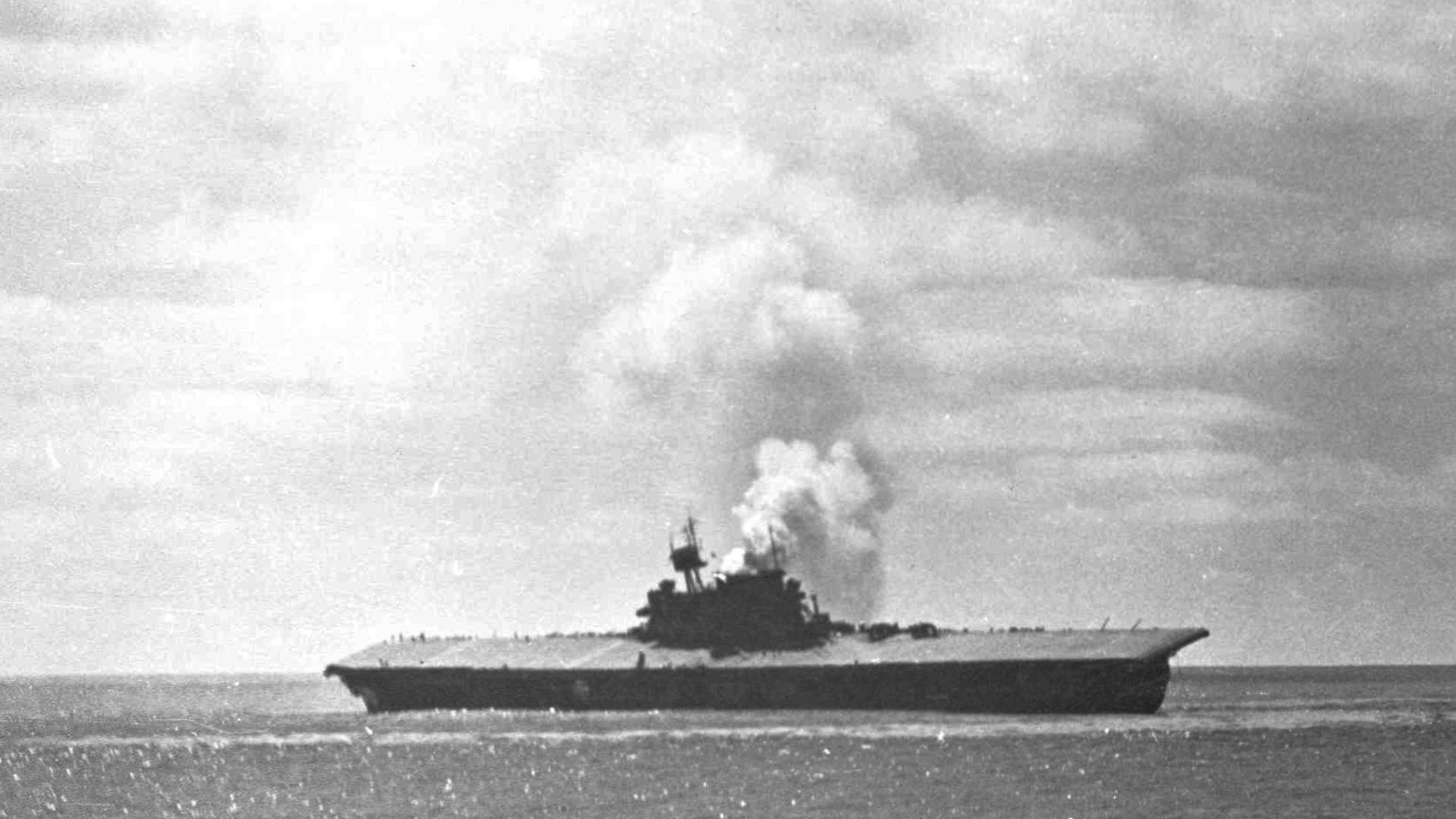 The U.S. aircraft carrier USS Yorktown (CV-5) damaged the Battle of Midway, 4 June 1942. The Yorktown lists heavily to the port side with smoke billowing from her funnel after an attack by Japanese aircraft during which she sustained three bomb hits and two torpedo hits. On 6 June 1942 the Japanese submarine I-168 scored another two torpedo hits on the crippled aircraft carrier and she sank on 7 June. Destroyers spent an entire day seeking out the Japanese submarine that sunk the Yorktown and her escort destroyer, USS Hammann (DD-412), but failed to sink I-168. The submarine was finally sunk by the USS Scamp (SS-277) on 27 July 1943.