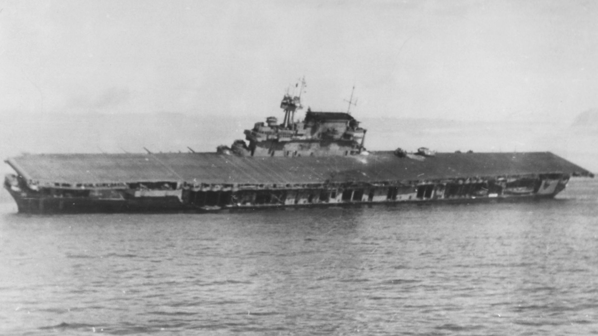 The U.S. Navy aircraft carrier USS Yorktown (CV-5) lists heavily after she was abandoned during the afternoon of 4 June 1942. Note that two Grumman F4F-4 Wildcat fighters of Fighting Squadron 3 (VF-3) are still parked on her flight deck, aft of the island.
