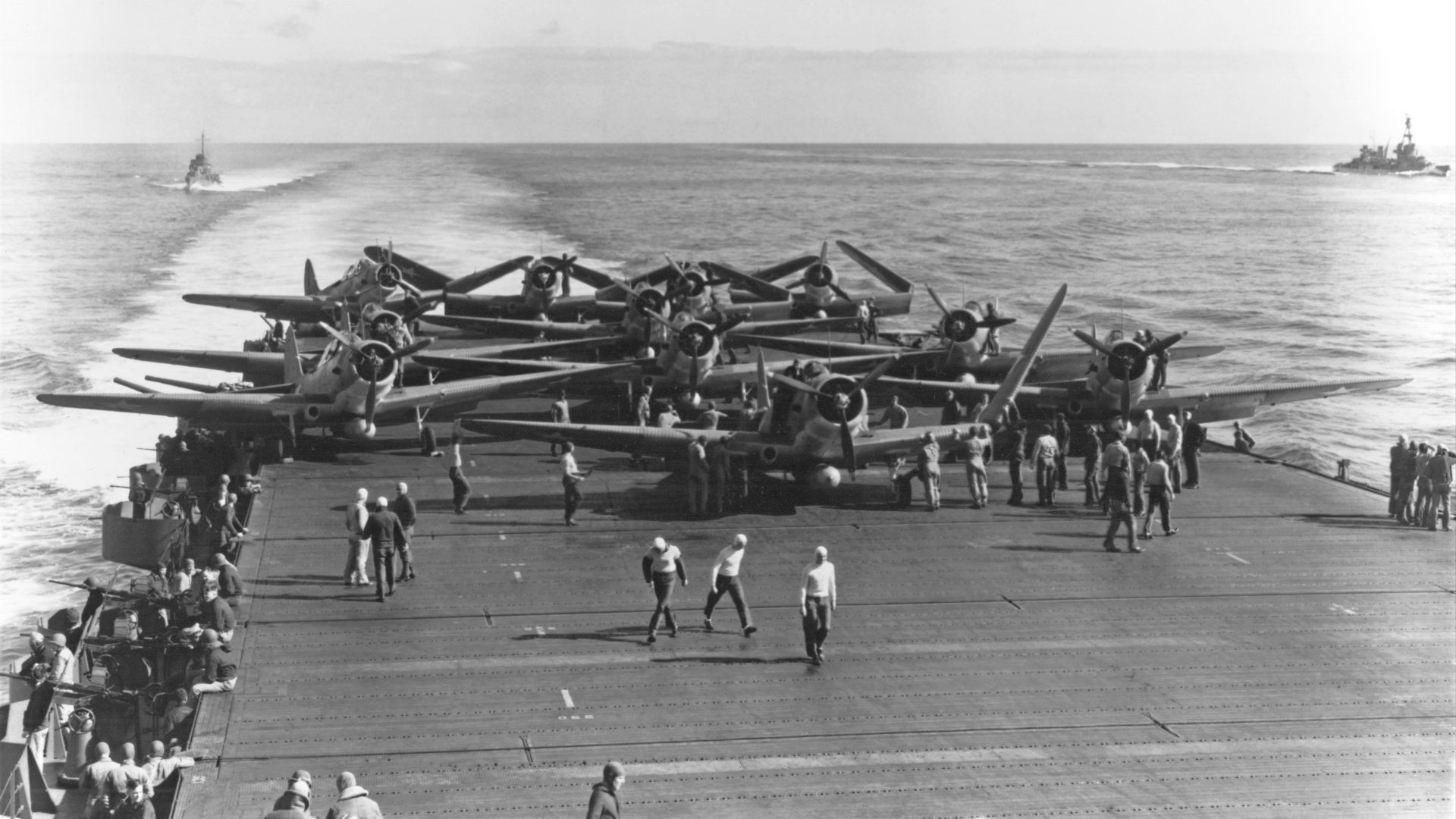 U.S. Navy Torpedo Squadron 6 (VT-6) Douglas TBD-1 Devastator aircraft are prepared for launching aboard the aircraft carrier USS Enterprise (CV-6) at about 0730-0740 hrs, 4 June 1942. Eleven of the fourteen TBDs launched from Enterprise are visible. Three more TBDs and ten Grumman F4F-4 Wildcat fighters must still be pushed into position before launching can begin.
The TBD in the left front is Number Two (BuNo 1512), flown by Ensign Severin L. Rombach and Aviation Radioman 2nd Class W.F. Glenn. Along with eight other VT-6 aircraft, this plane and its crew were lost attacking Japanese aircraft carriers somewhat more than two hours later.

The heavy cruiser USS Pensacola (CA-24) is in the right distance and a destroyer is in plane guard position at left.
