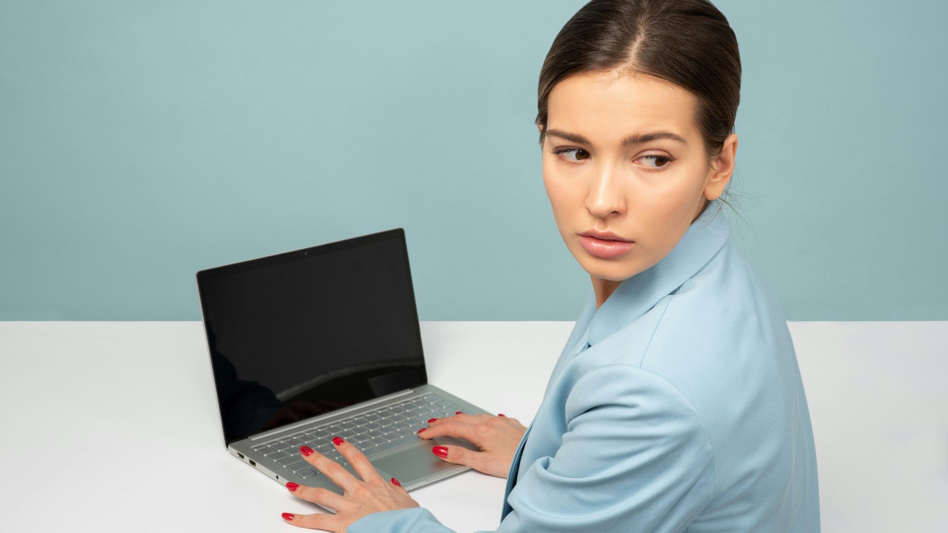 woman using laptop and looking side
