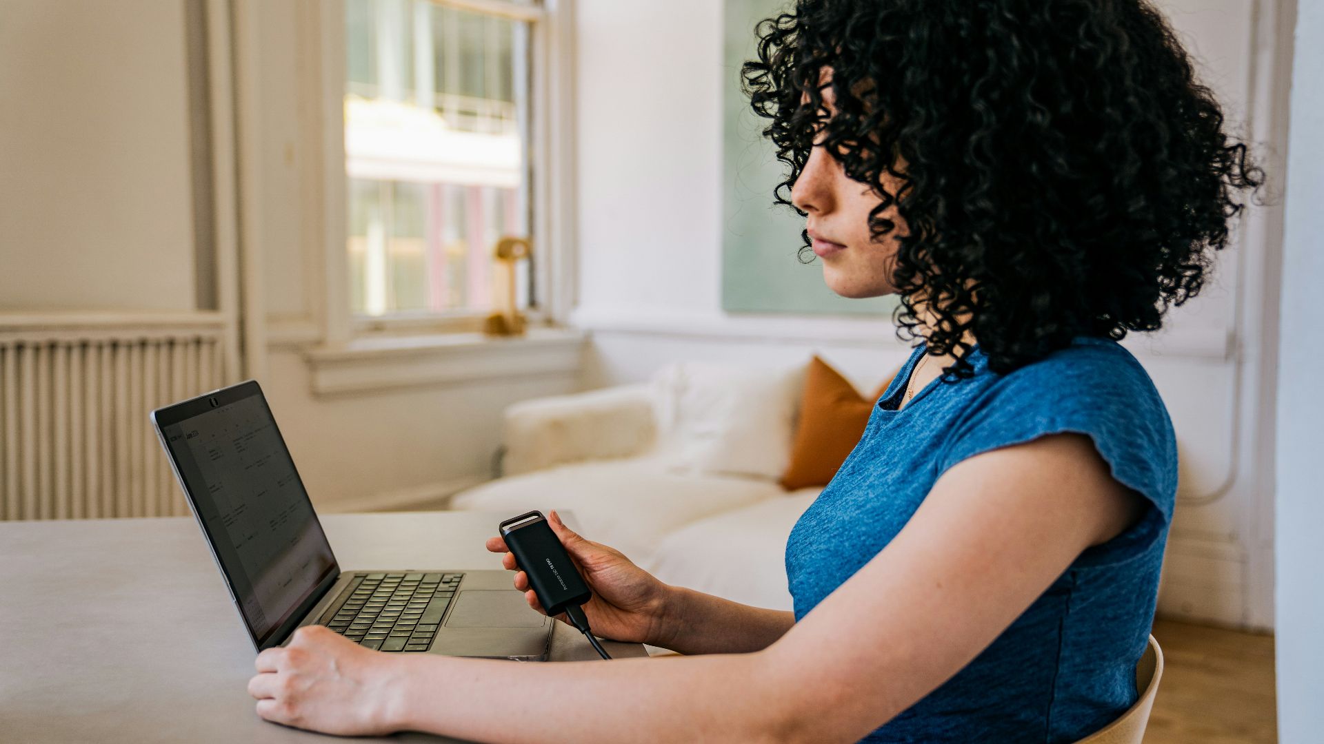 A woman sitting at a table using a laptop computer