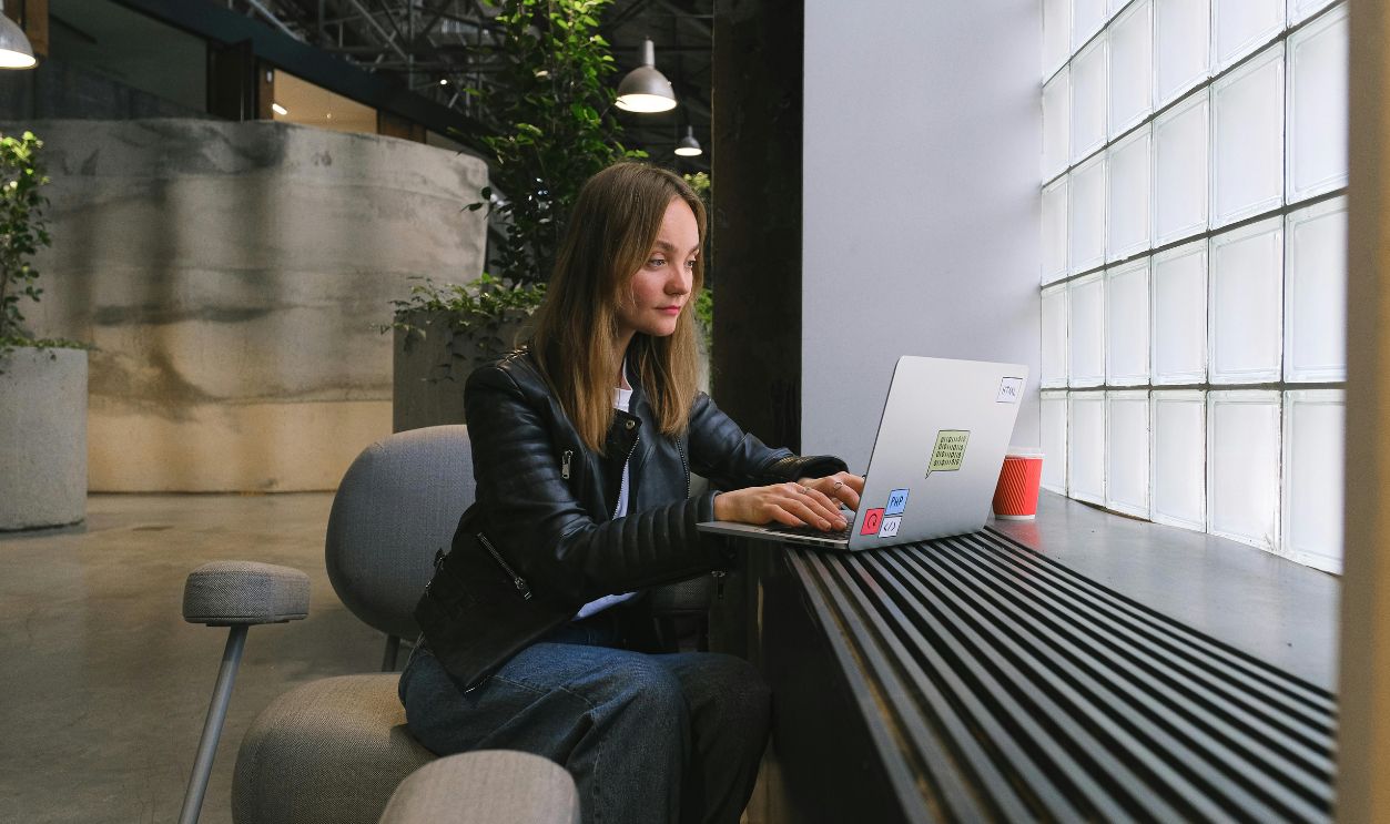 Young woman working on a laptop in a stylish modern office with natural lighting