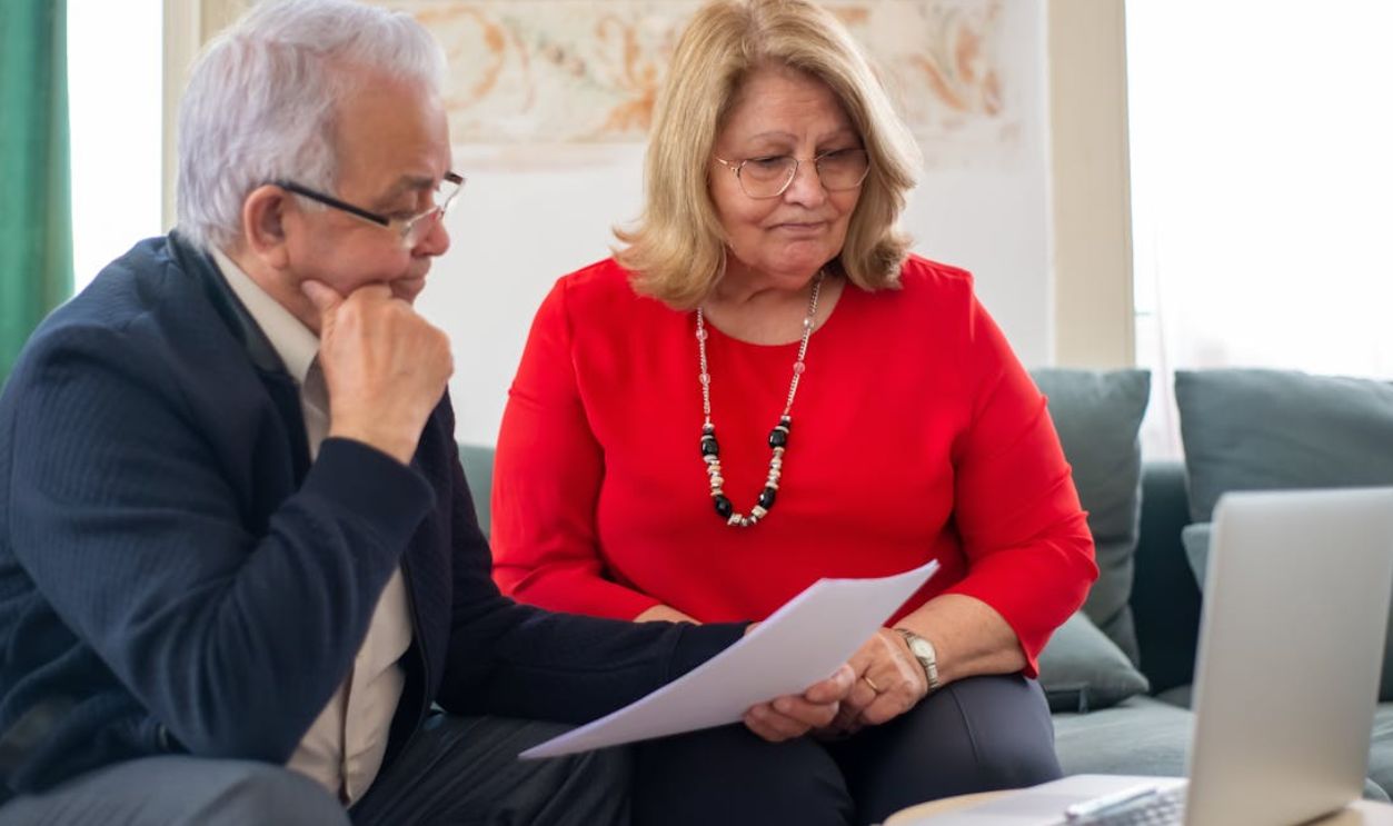 Elderly couple reviewing financial documents together at home in Portugal